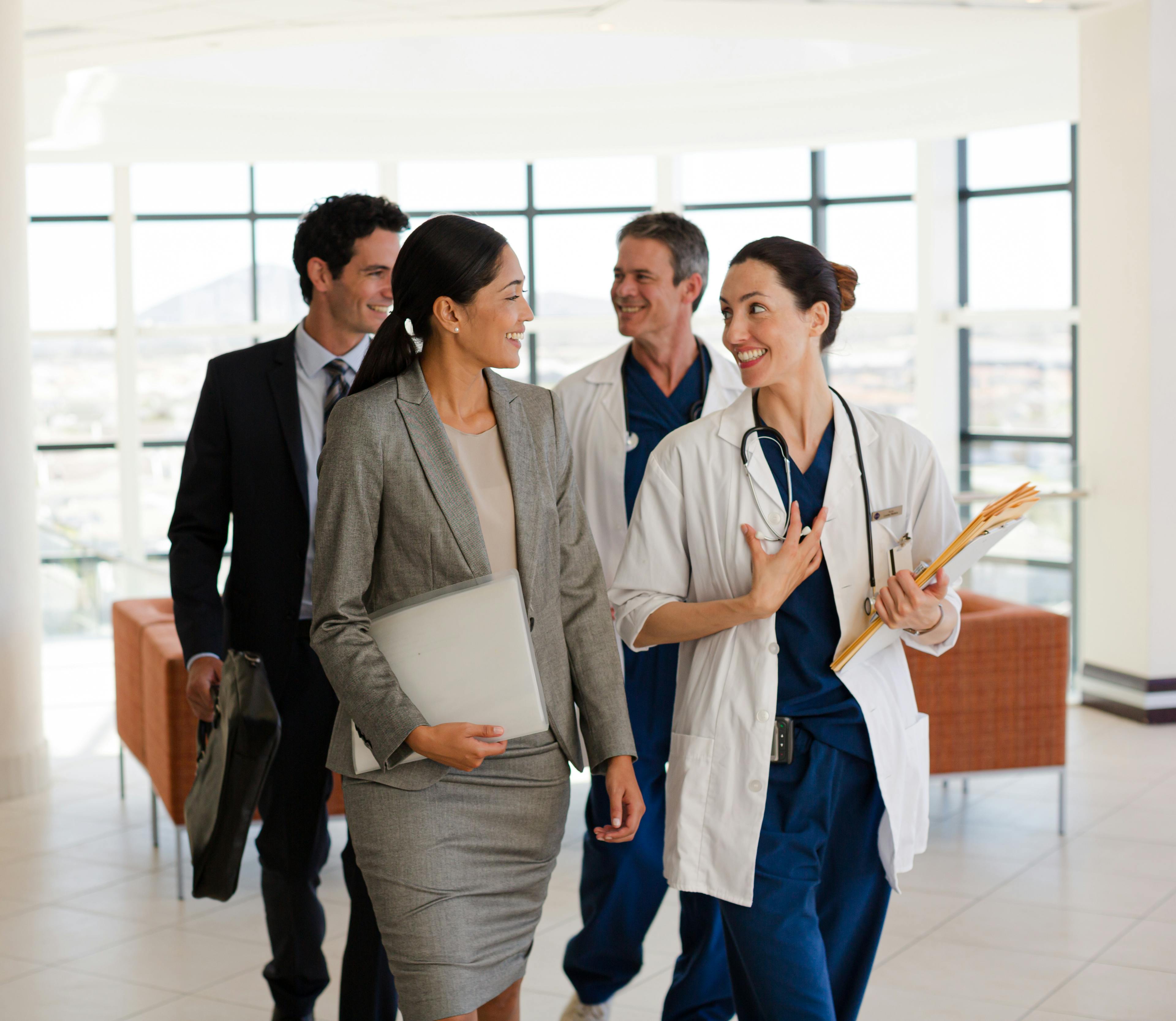 Doctors and business professionals engaged in a discussion in a professional setting.