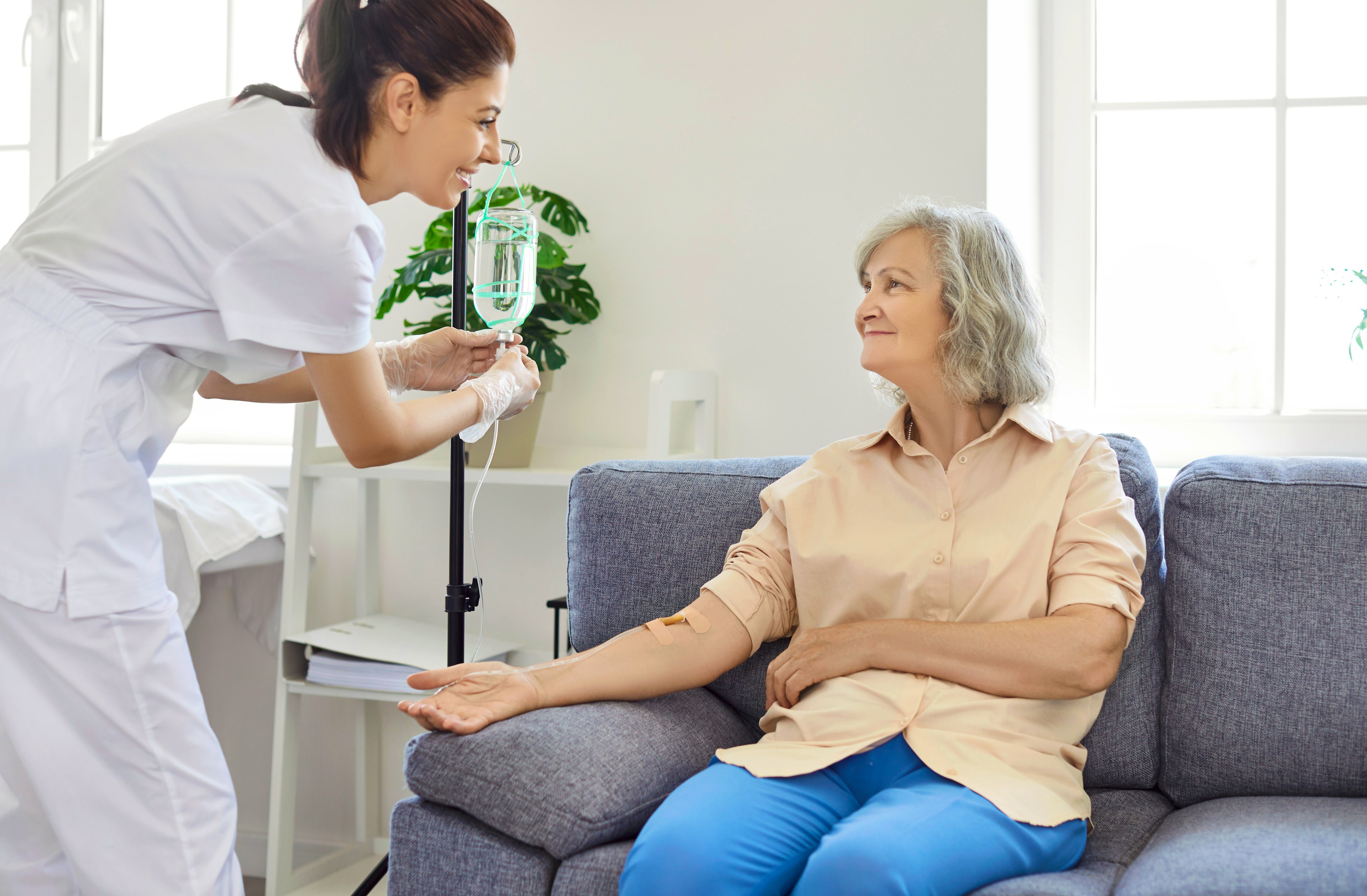 Healthcare provider preparing an infusion for female patient 