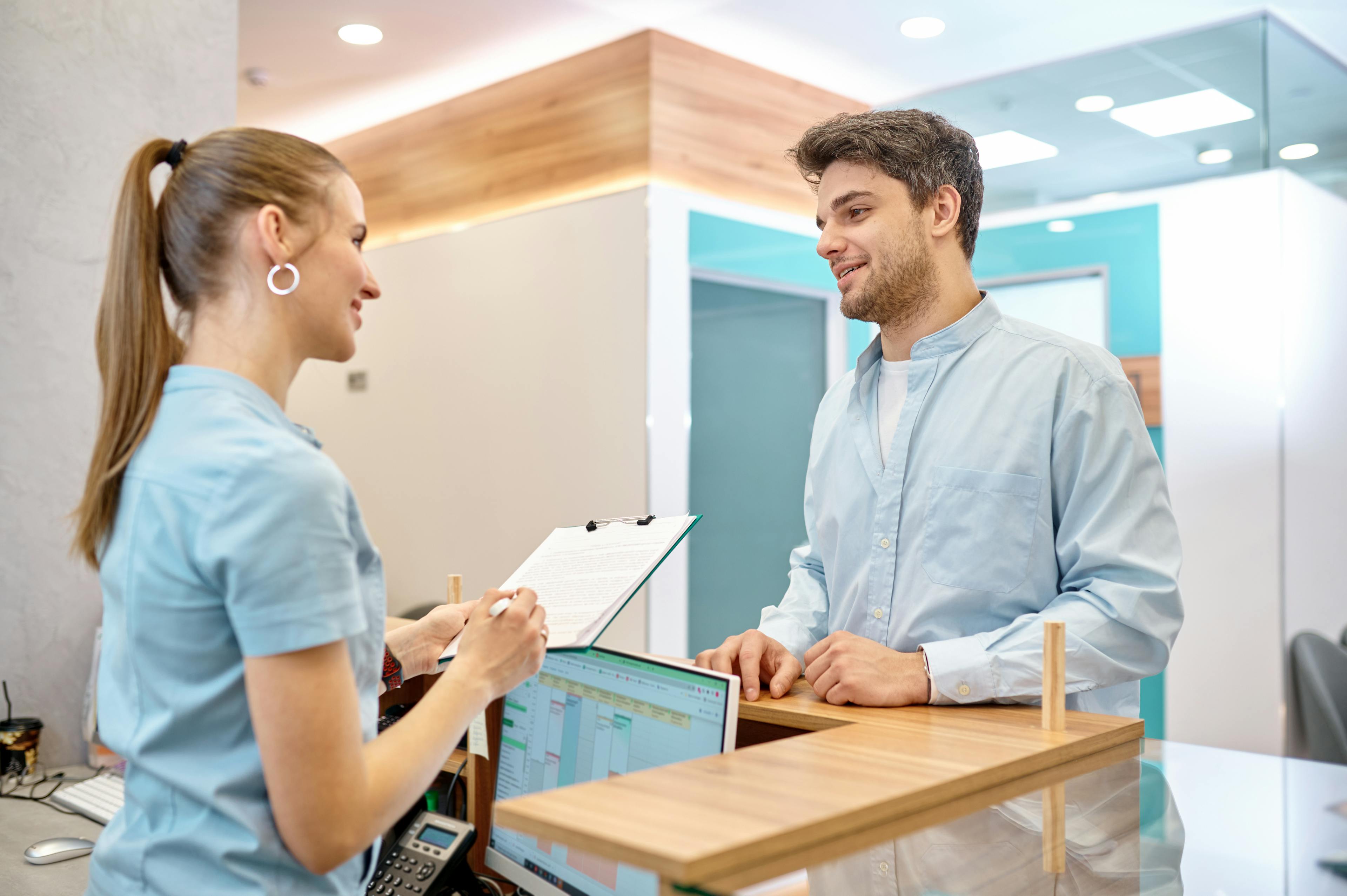 Pictured is a receptionist helping a patient in a medical clinic.