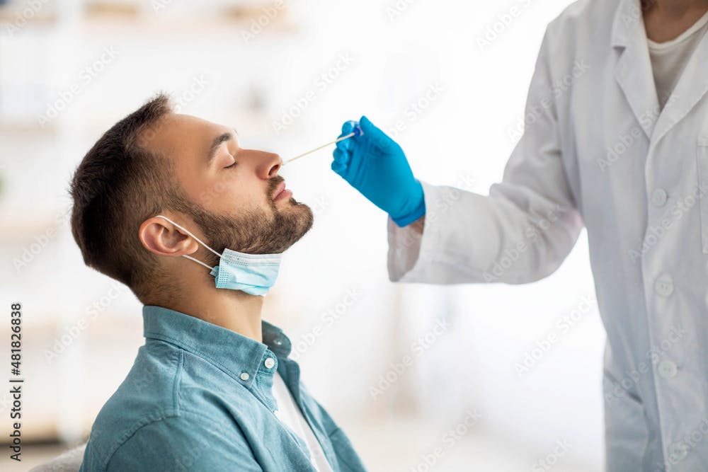 A healthcare provider swabbing a patient's nose.