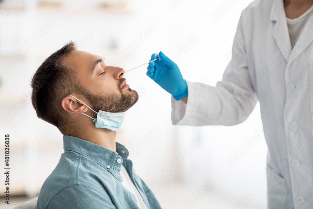 A healthcare provider swabbing a patient's nose.