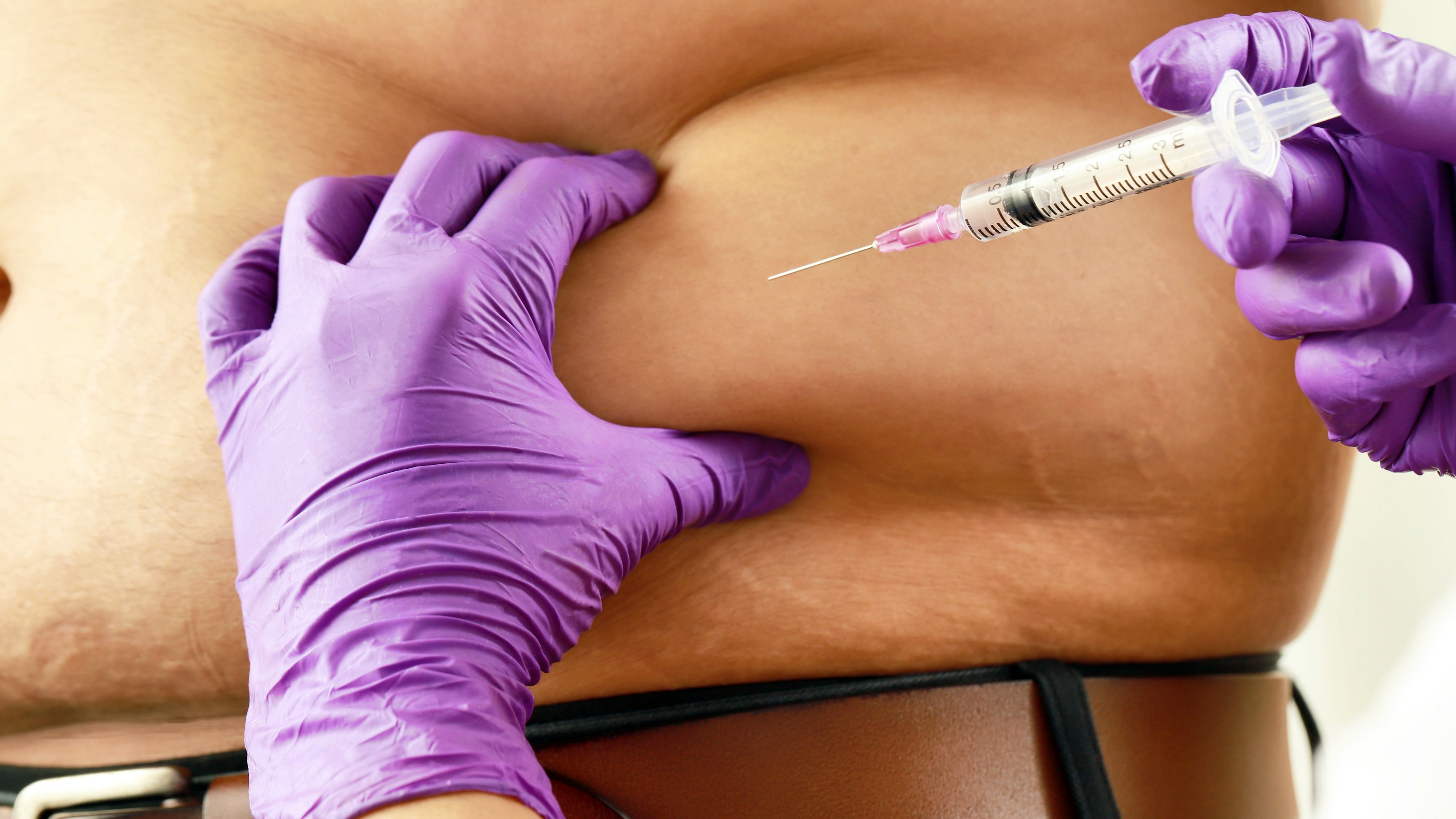 A patient receiving an injection in the abdominal region.
