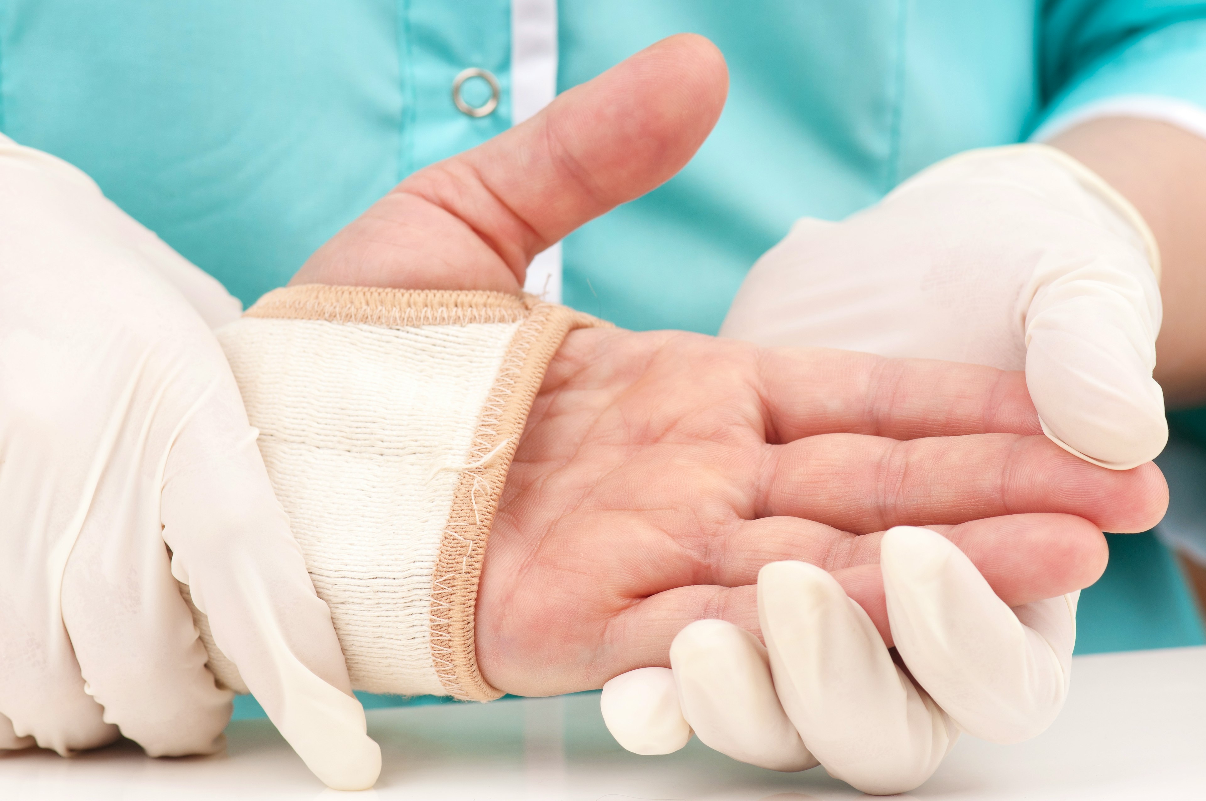 A hand surgeon examining palm side of a patient's hand. 