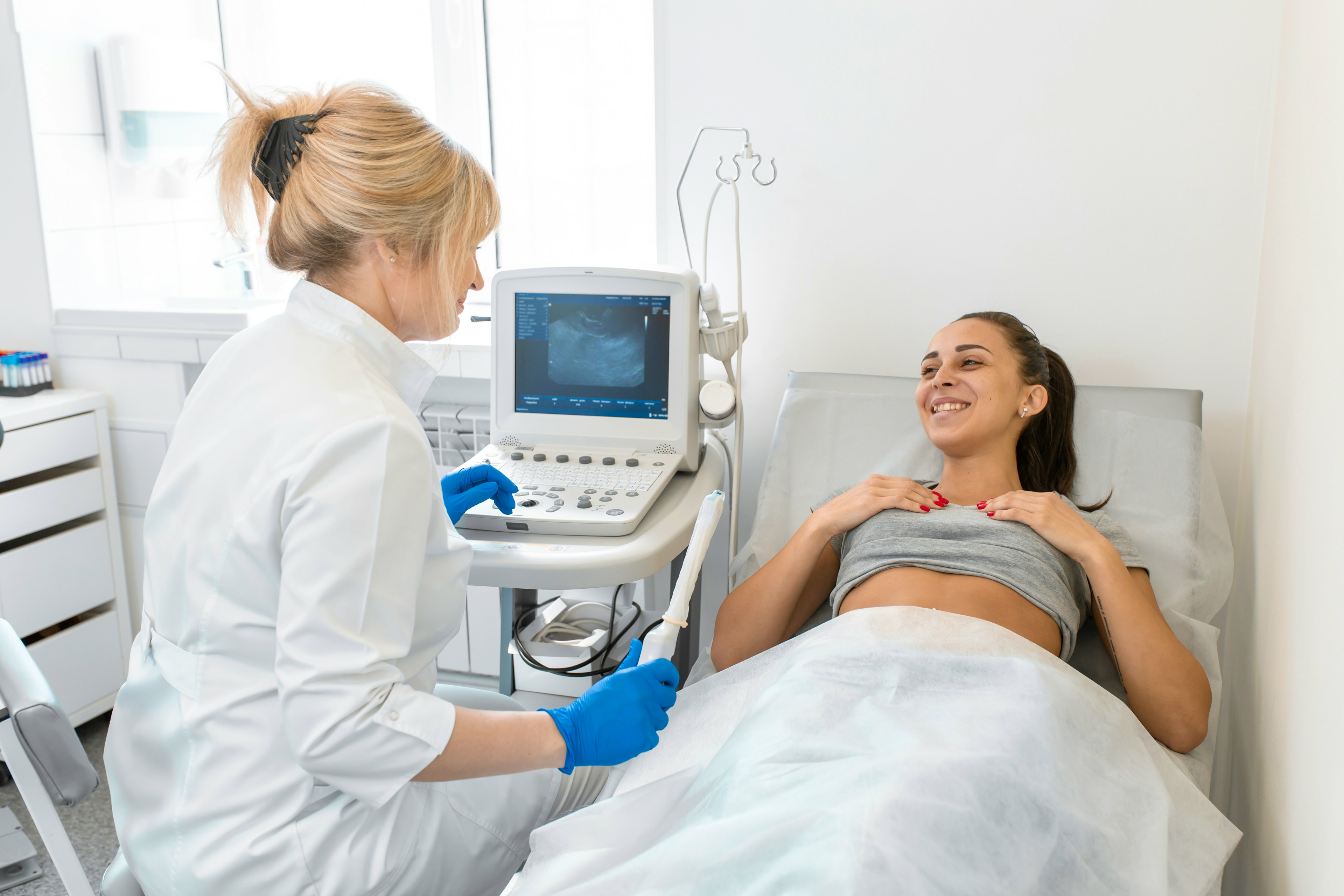 A female gynecology specialist preparing to perform an ultrasound on a patient.