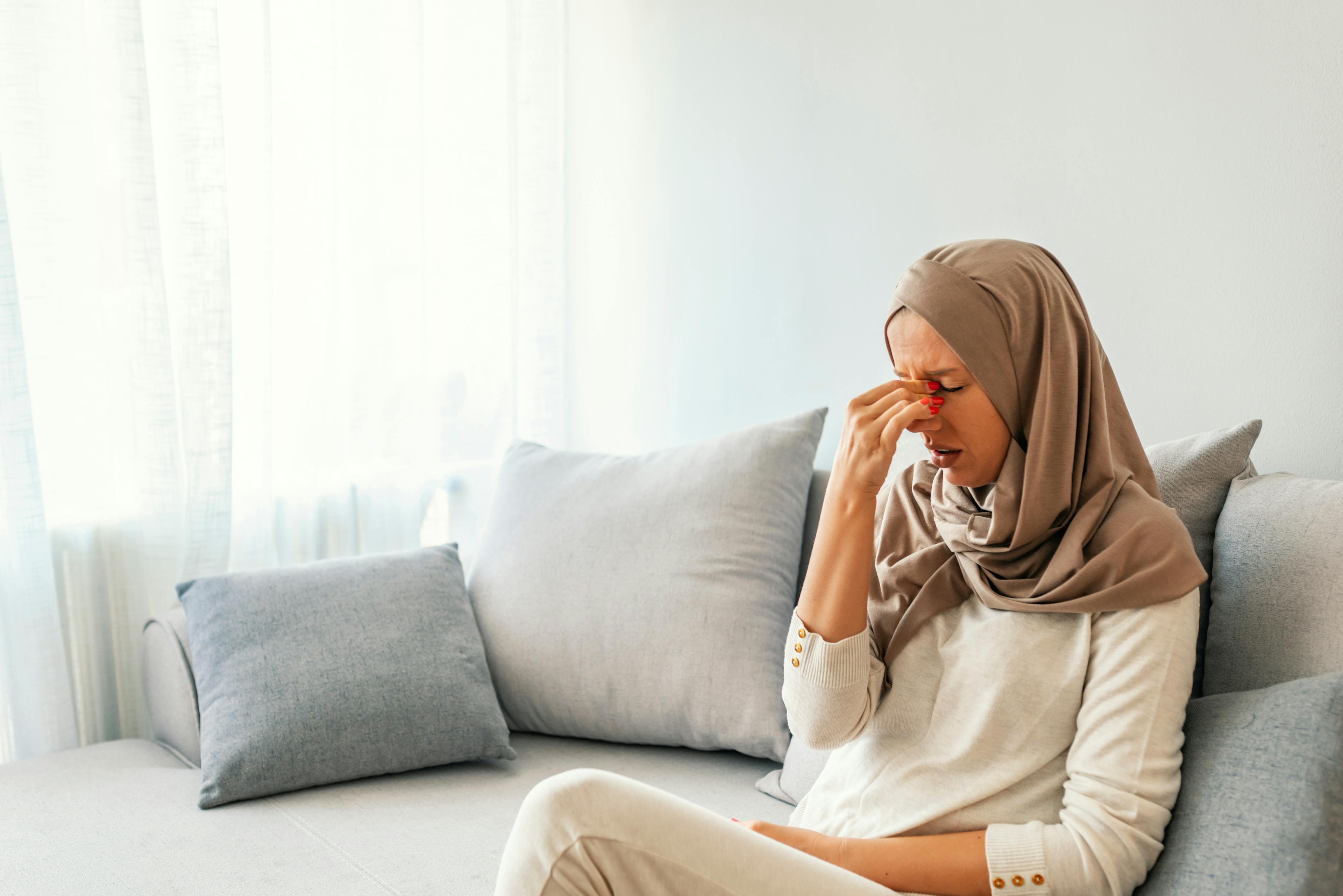 Woman holding her nose and head because of sinus pain.