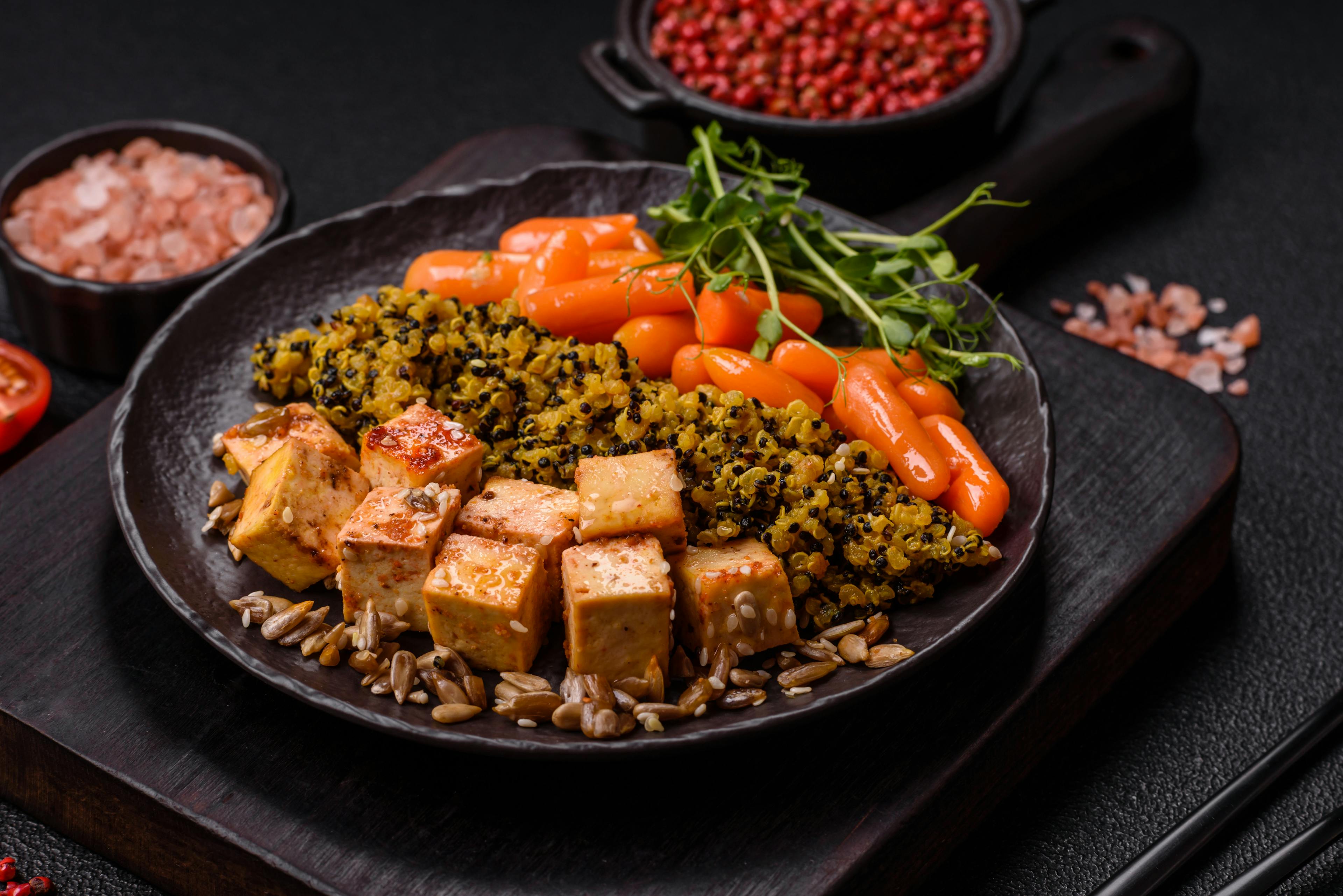 Quinoa bowl with tofu steamed vegetables, grains, seeds, and spices