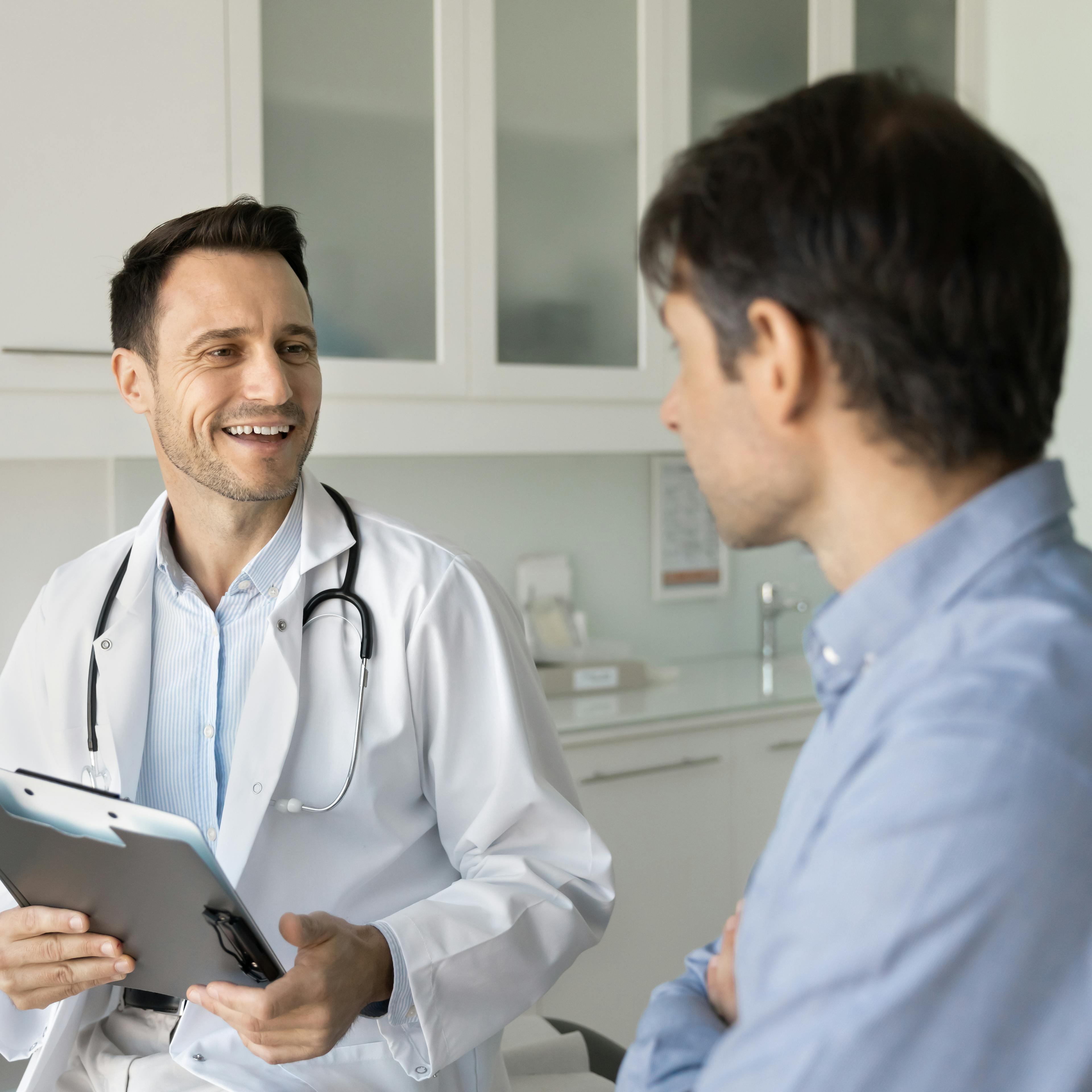 Urologist consulting with a patient in a medical exam room.