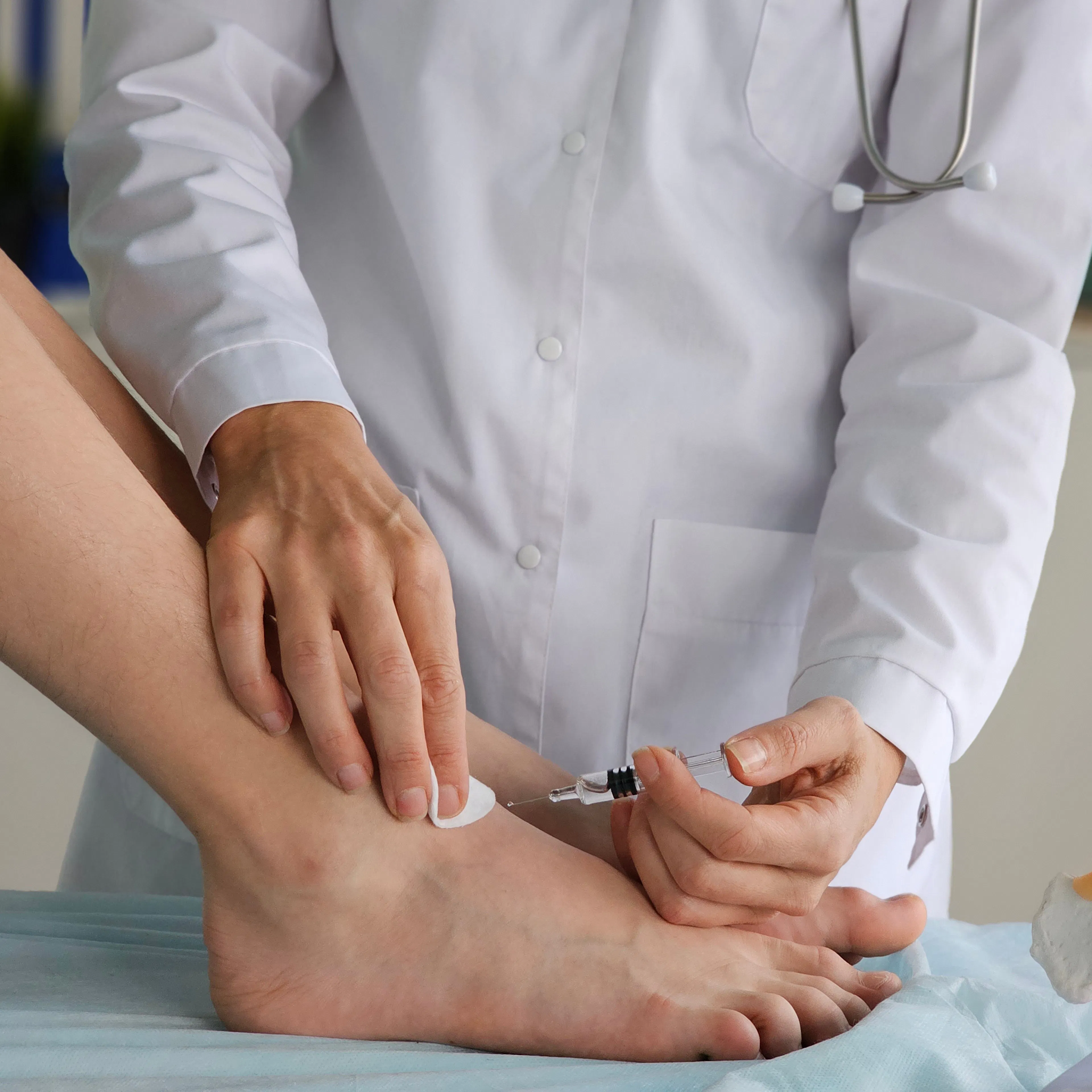 An orthopedic surgeon injects medicine into the Achilles tendon to relieve pain.