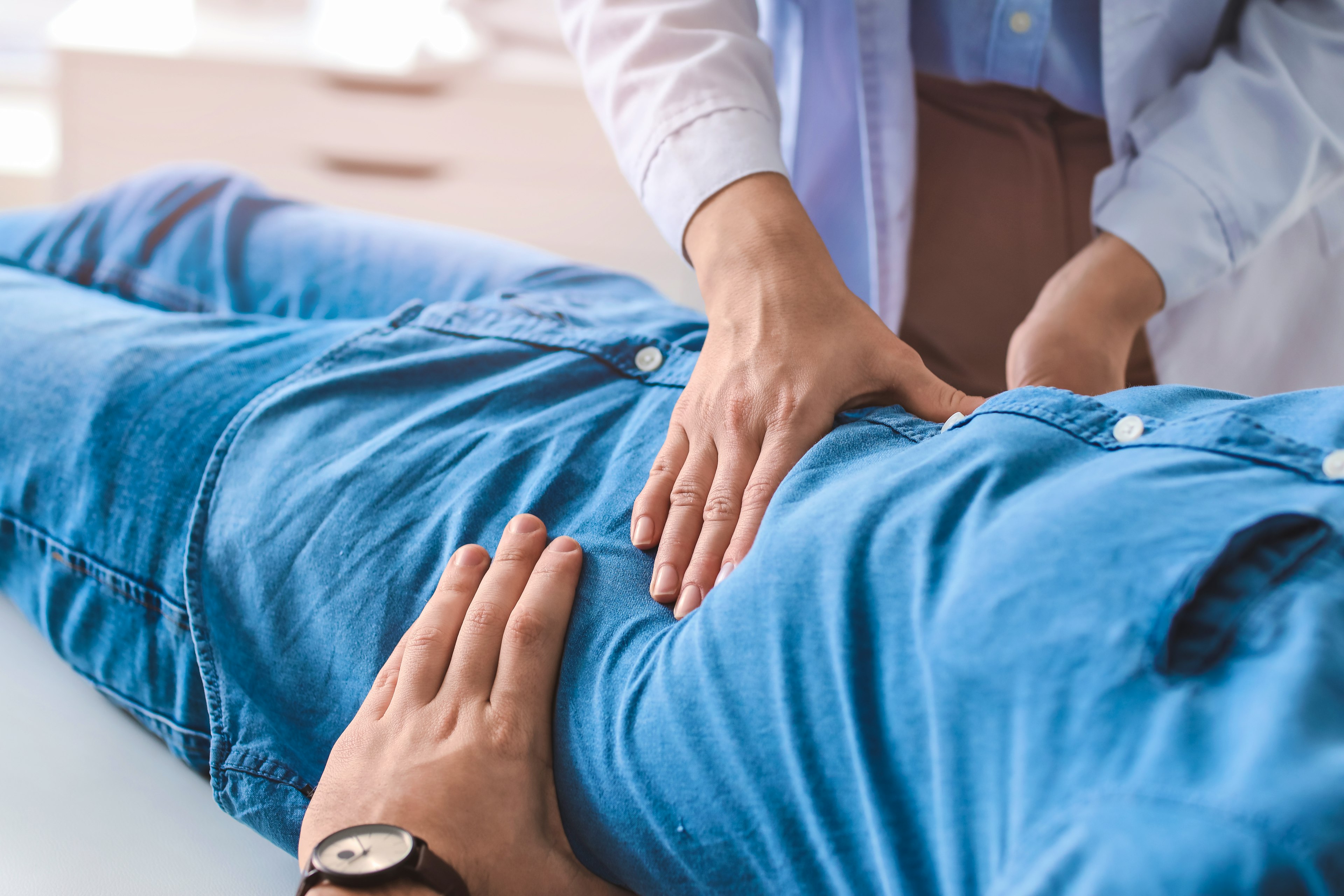 Gastroenterologist examining a man in clinic.