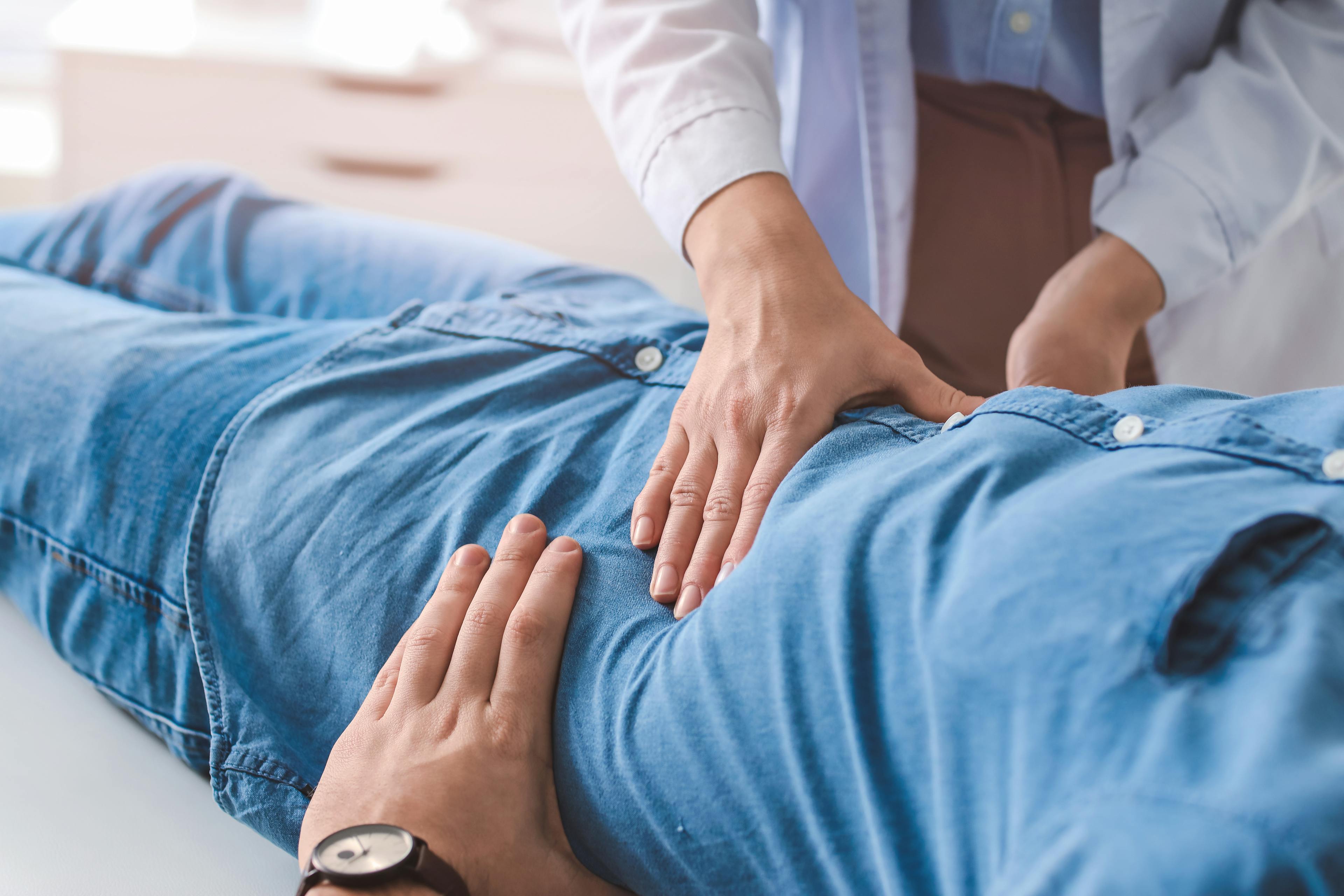 Gastroenterologist examining a man in clinic.