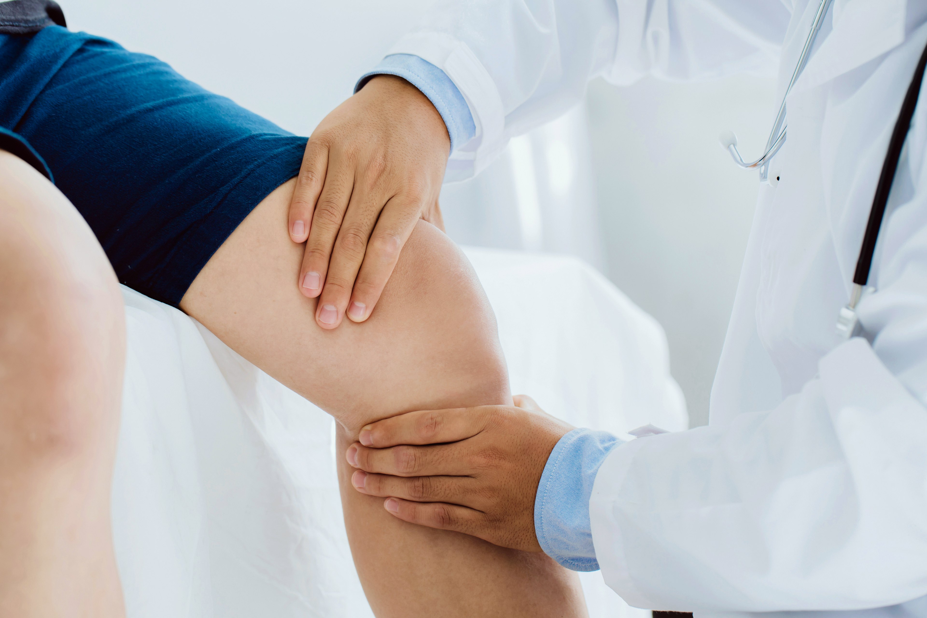 Doctor examining the injured knee of patient.