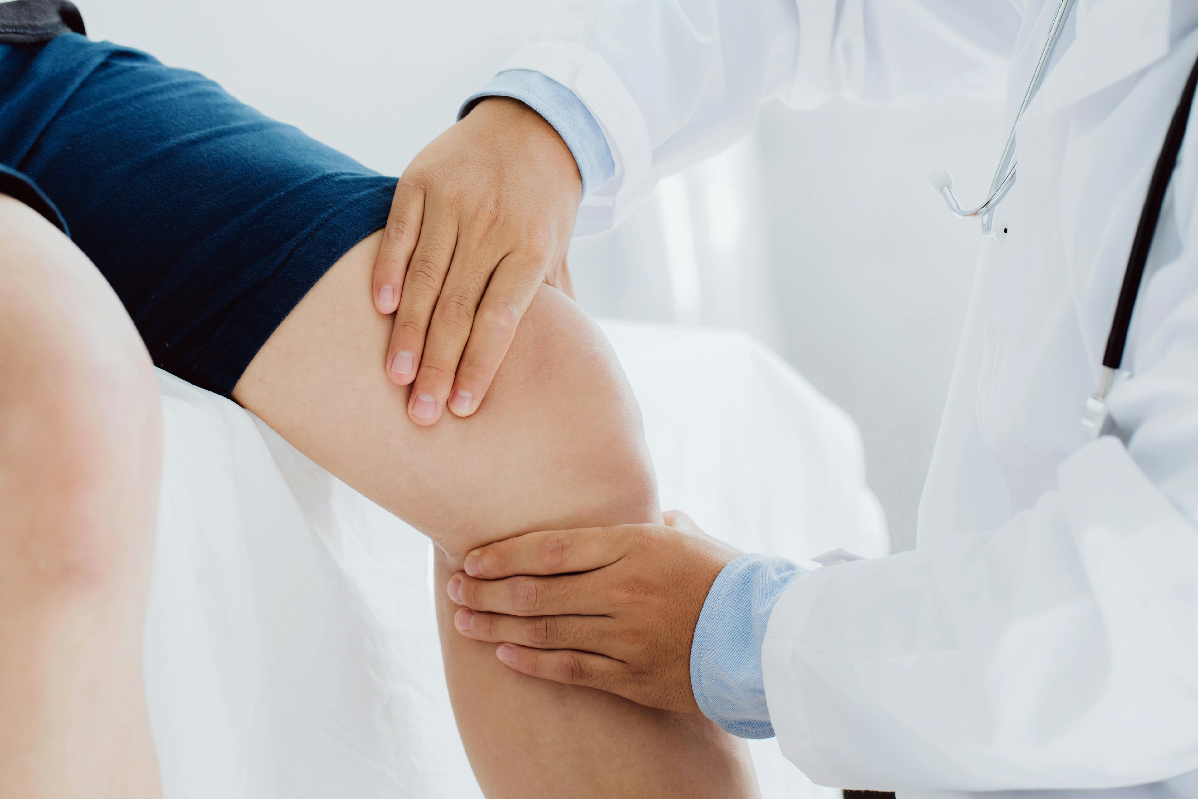 Doctor examining the injured knee of patient.