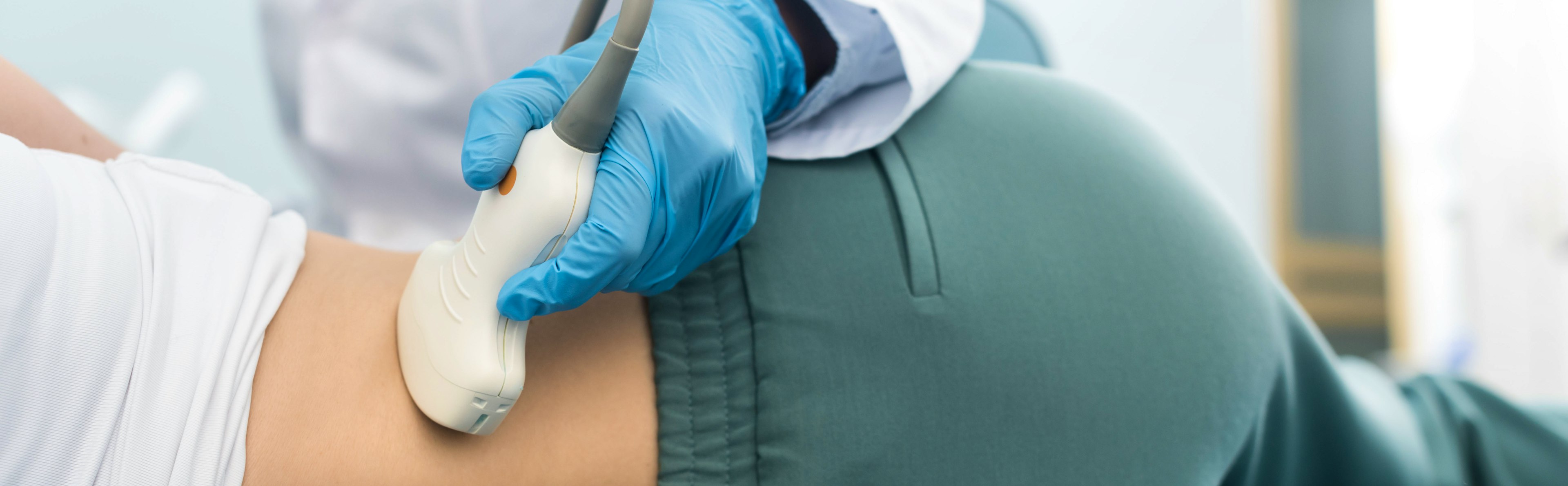 Partial view of young doctor examining kidney of patient with ultrasound scan, panoramic shot.
