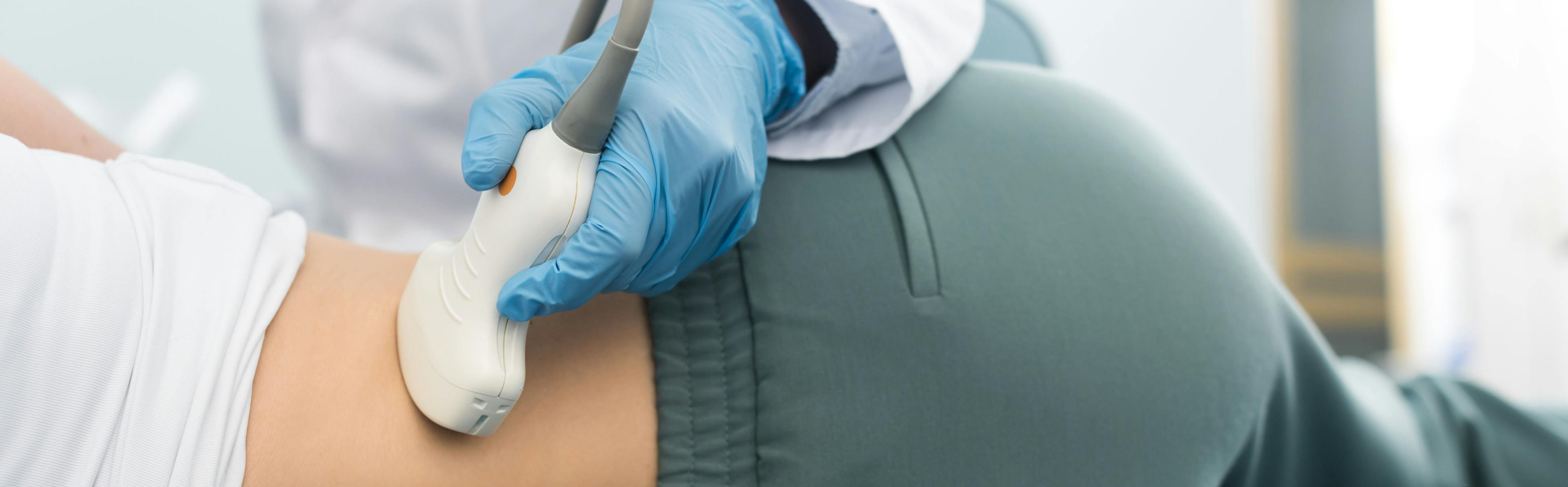Partial view of young doctor examining kidney of patient with ultrasound scan, panoramic shot.
