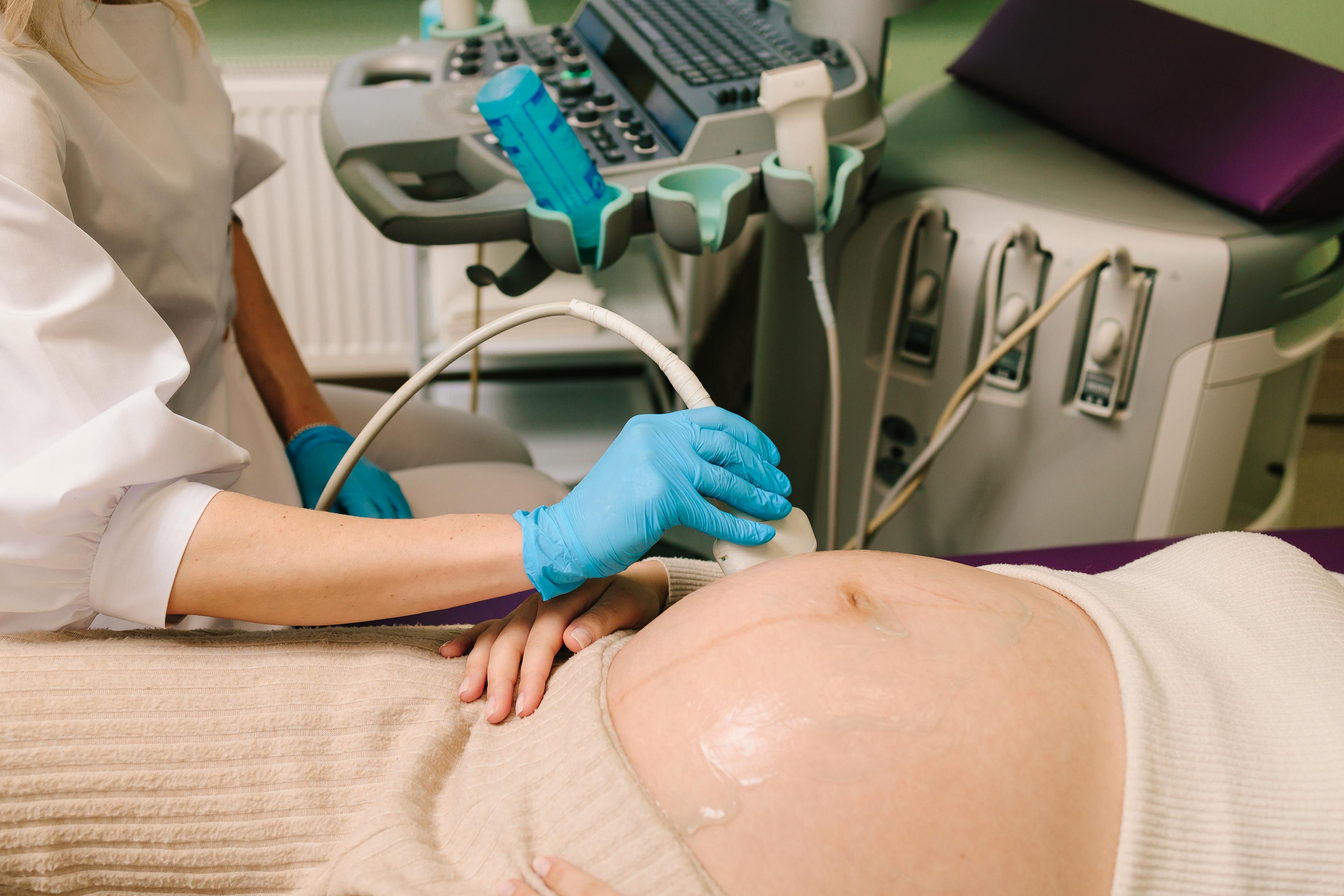 Closeup of pregnant woman's belly on the monthly checkup at the maternity center.