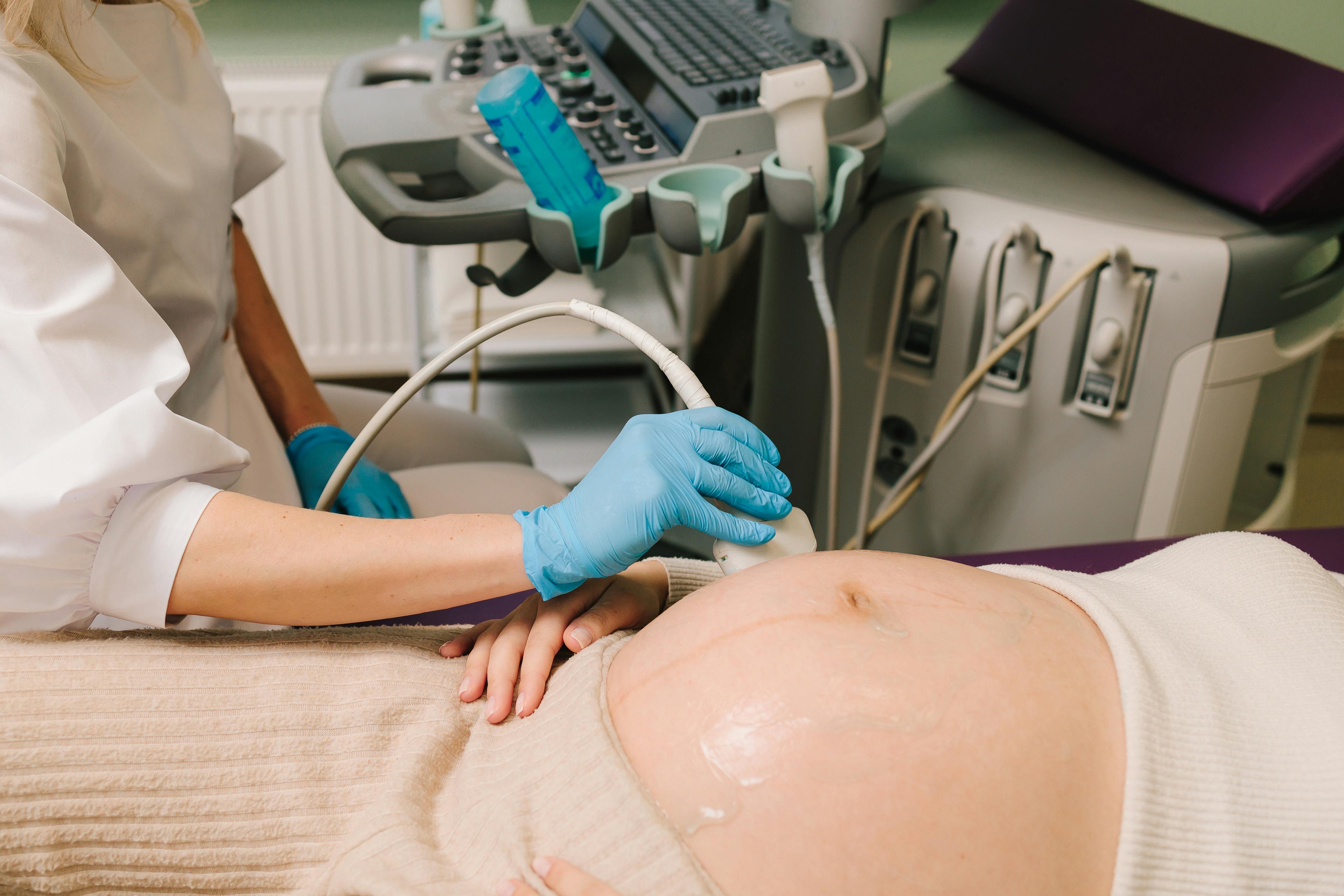 Closeup of pregnant woman's belly on the monthly checkup at the maternity center.