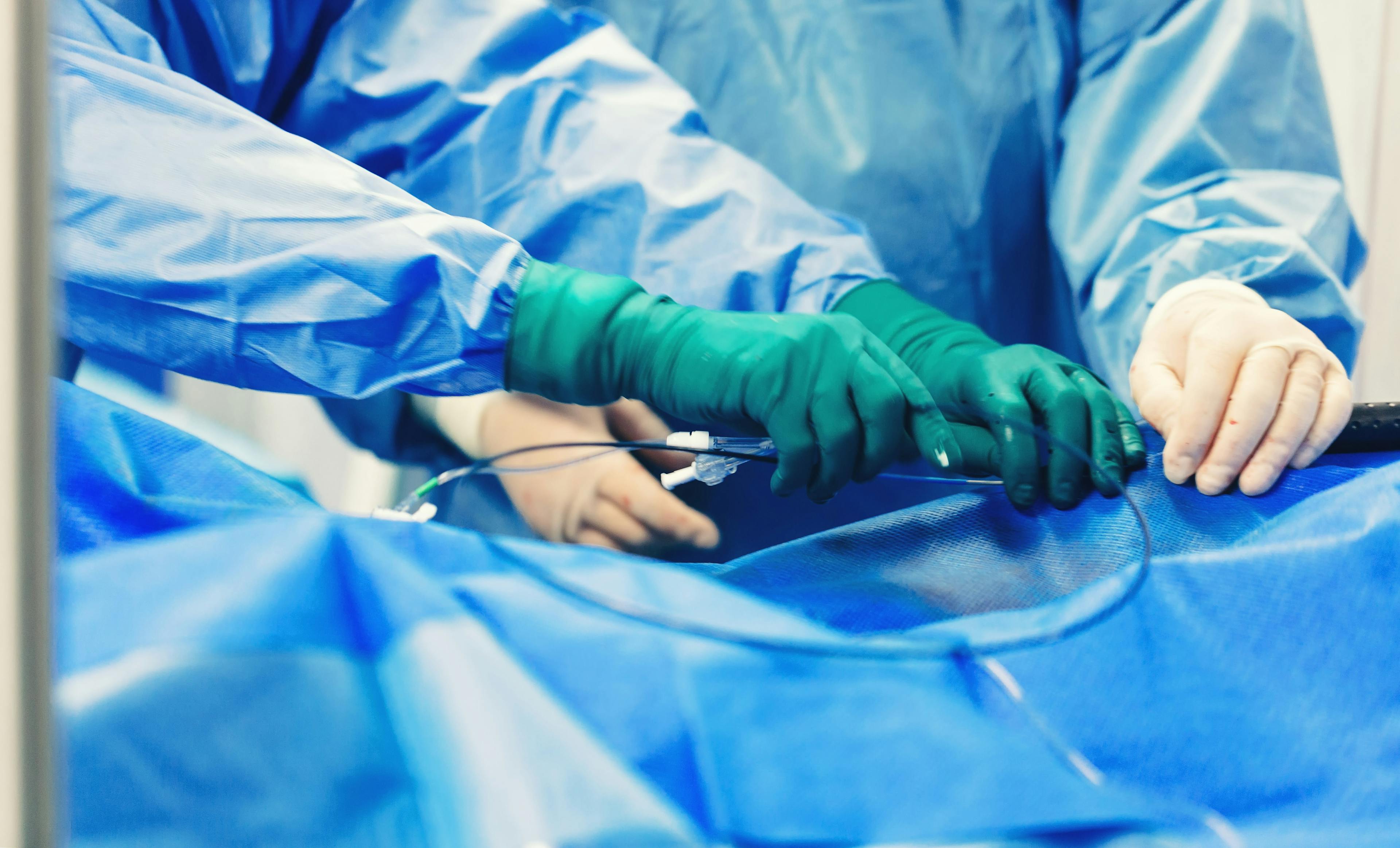 Team of cardiologist minimally invasive cardiology transcatheter closure treatment for patent foramen ovale PFO defects with occluder, using a endovascular procedure with cardiovascular imaging system.