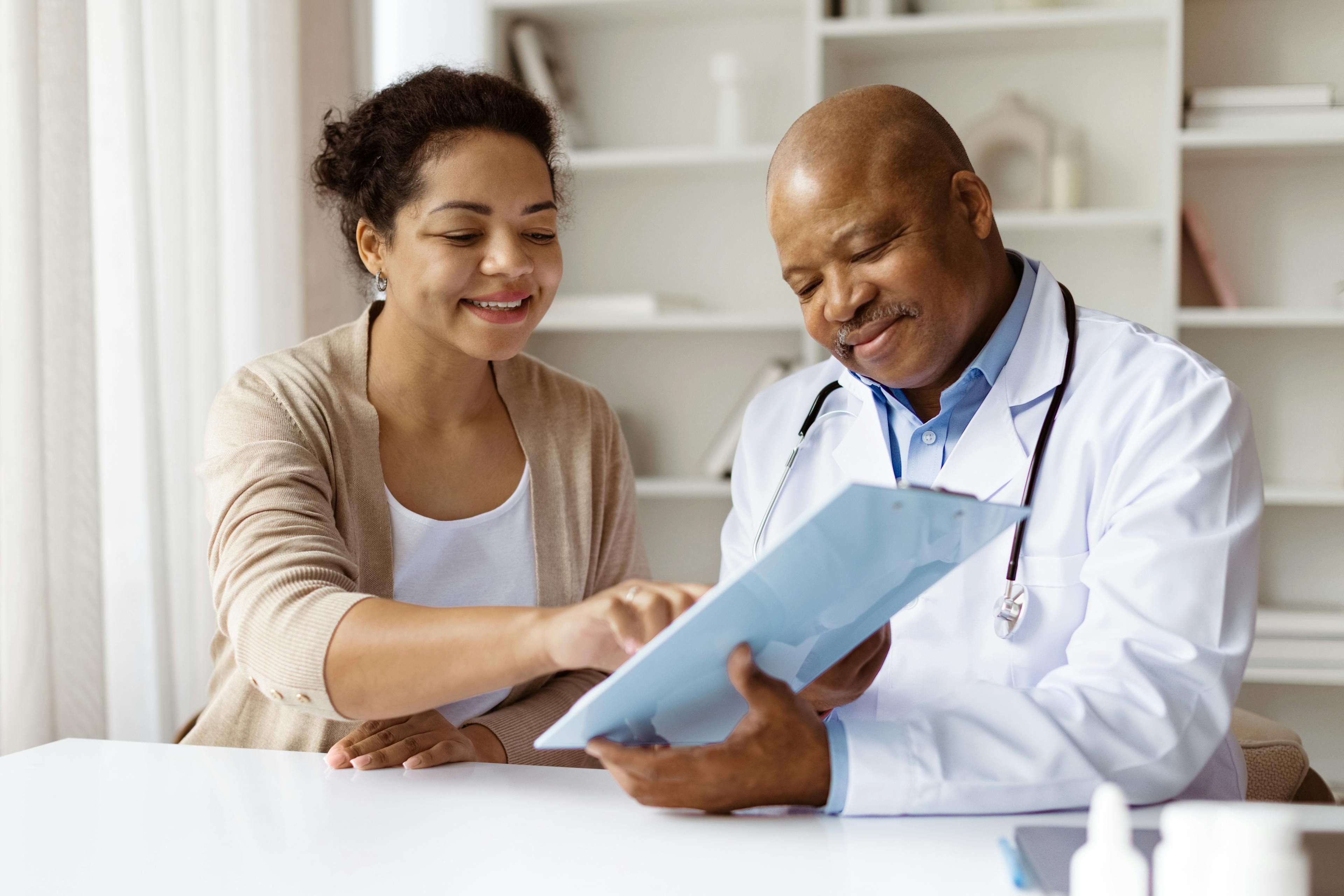 A doctor is reviewing medical records with his patient. 