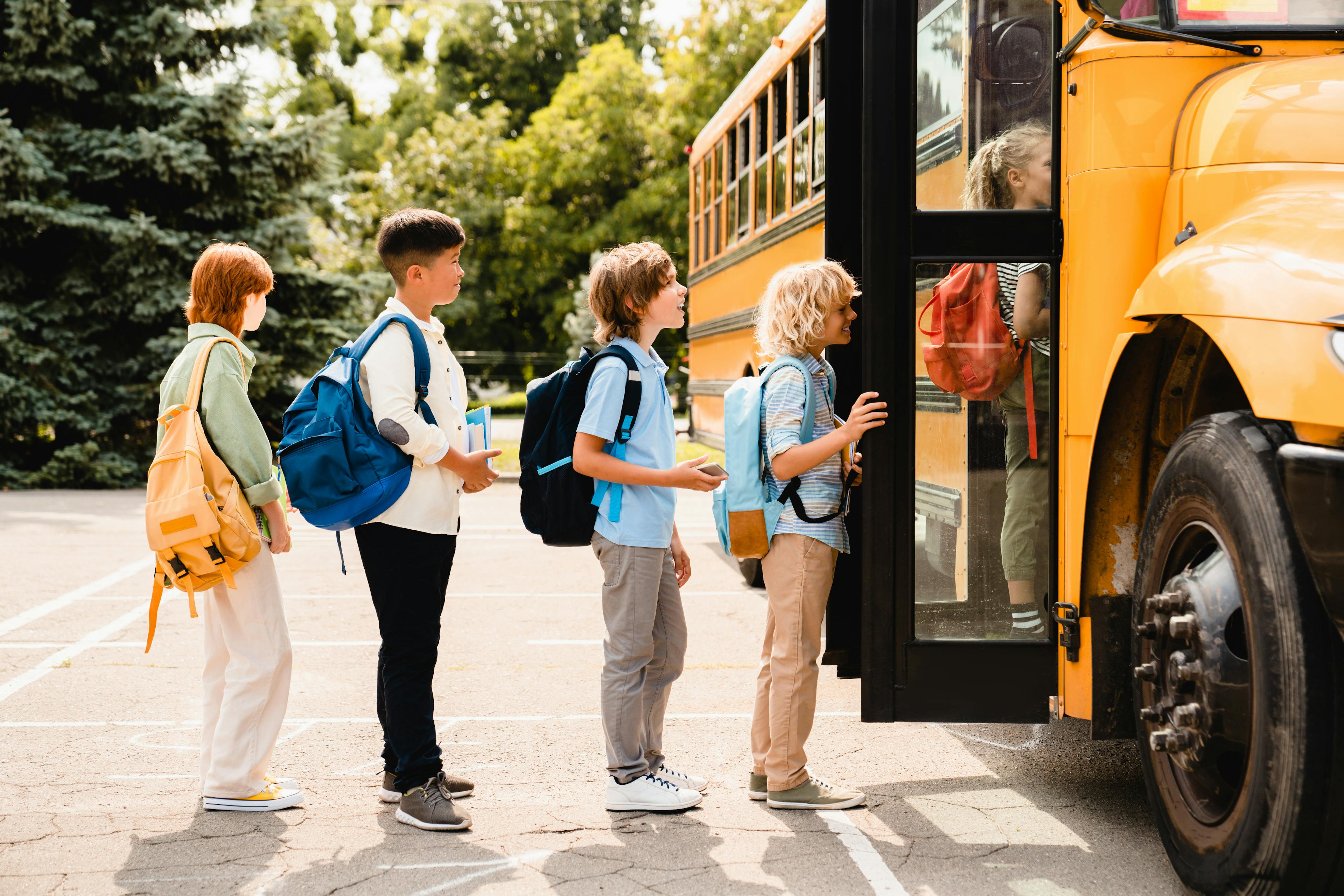 Kids lined up getting into a school bus.