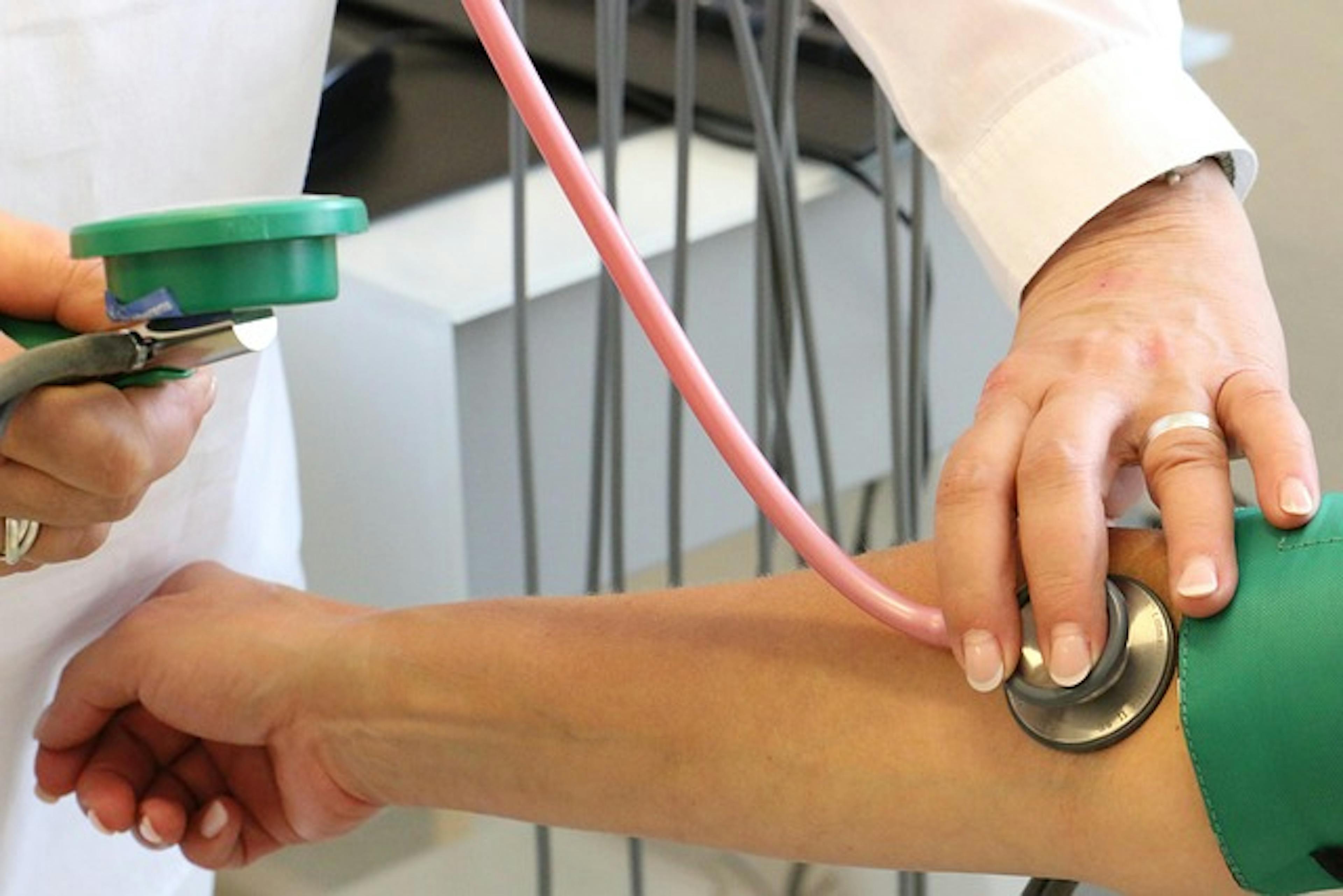 The doctor checks a patient's heart rate.