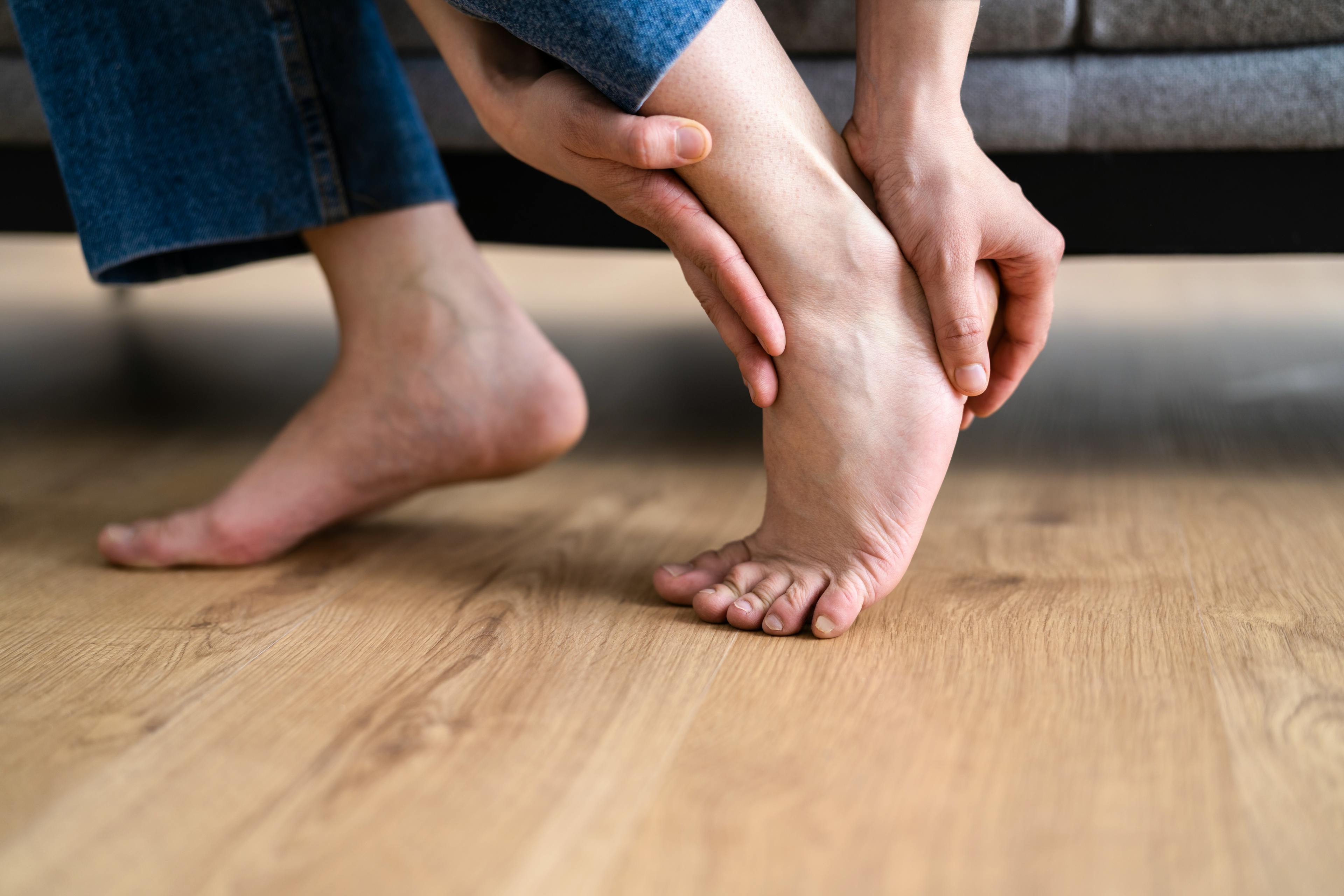 Woman grabbing her heel in pain.