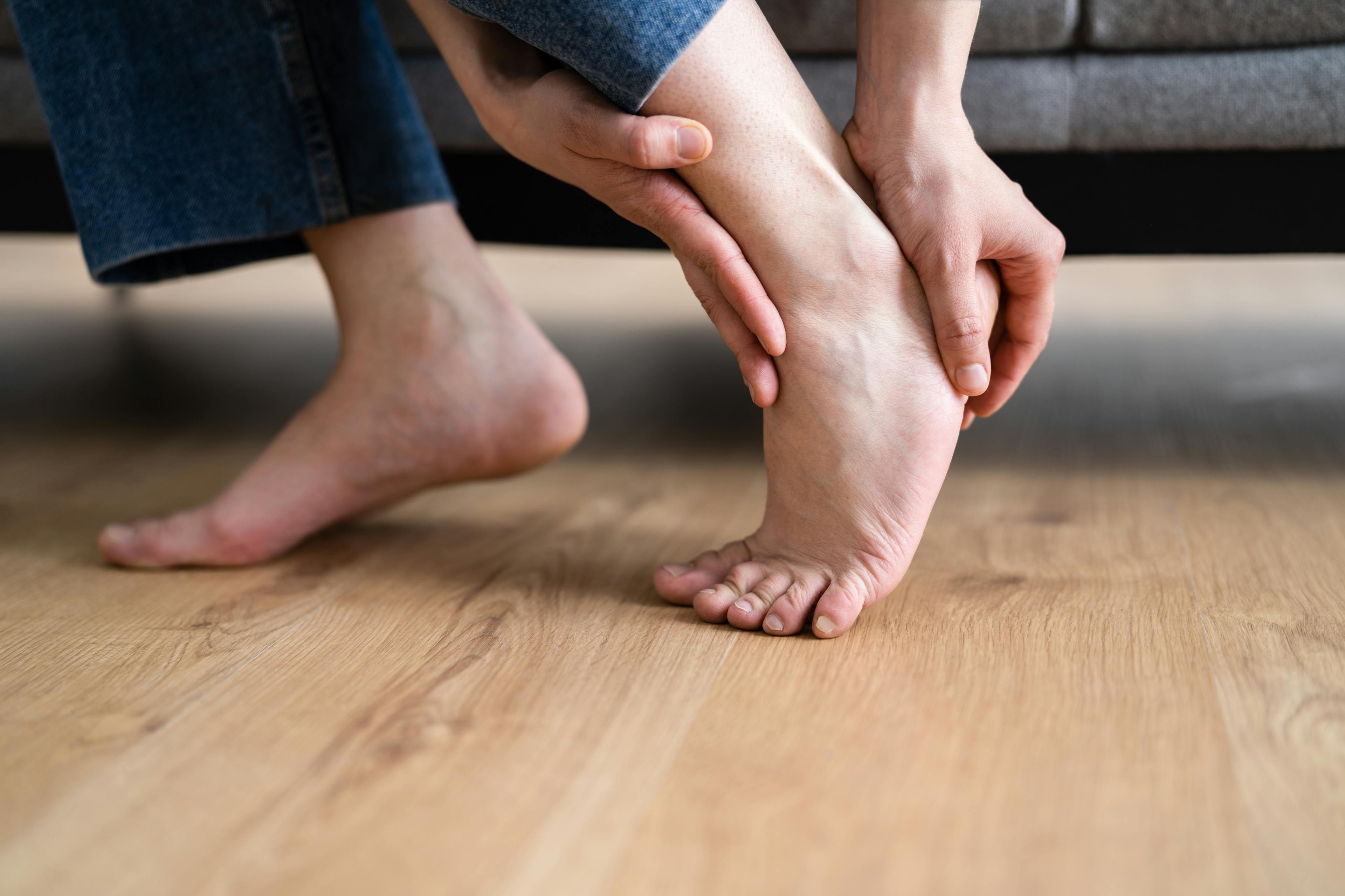 Woman grabbing her heel in pain.