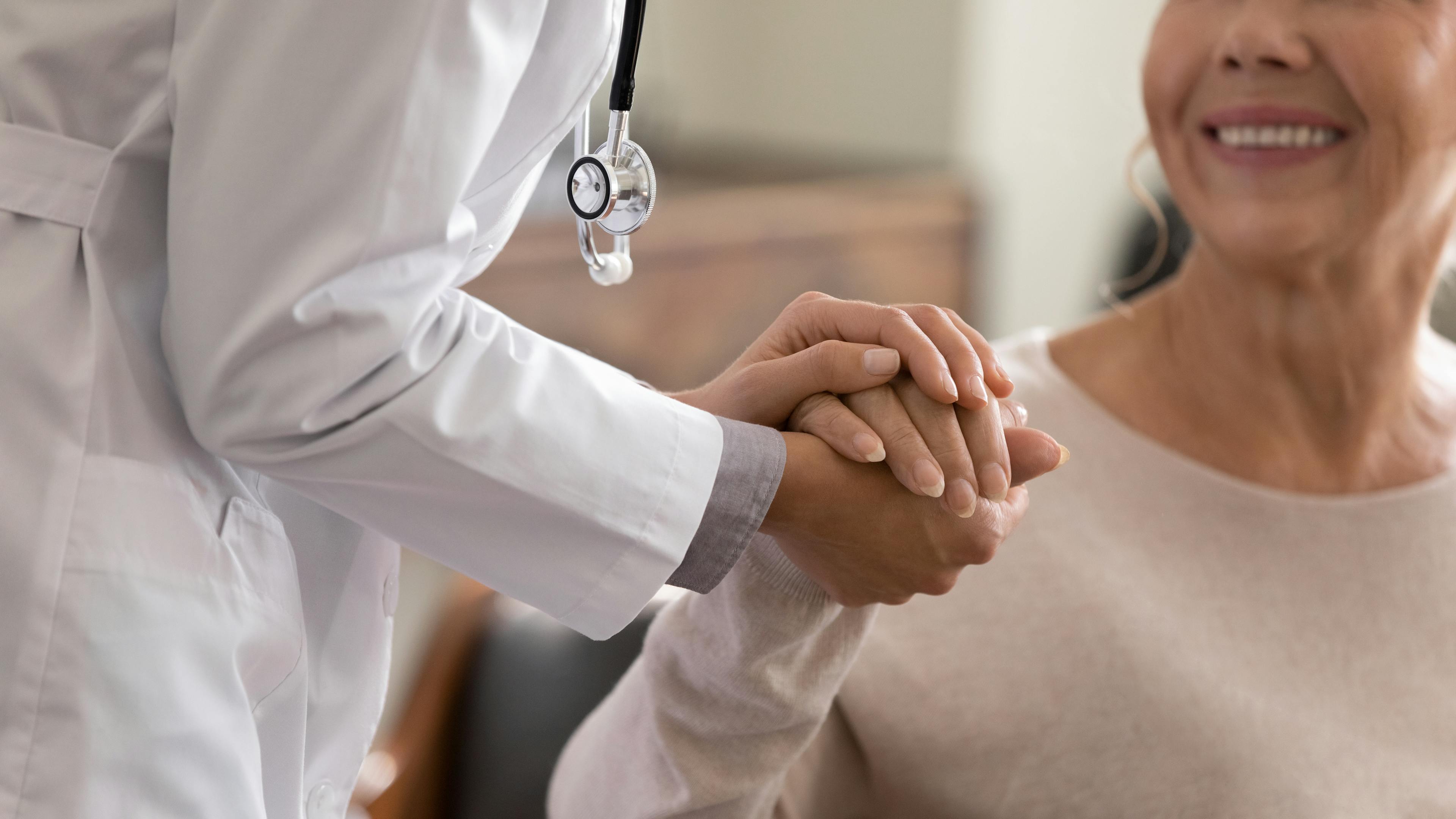 Doctor holding patient's hand.