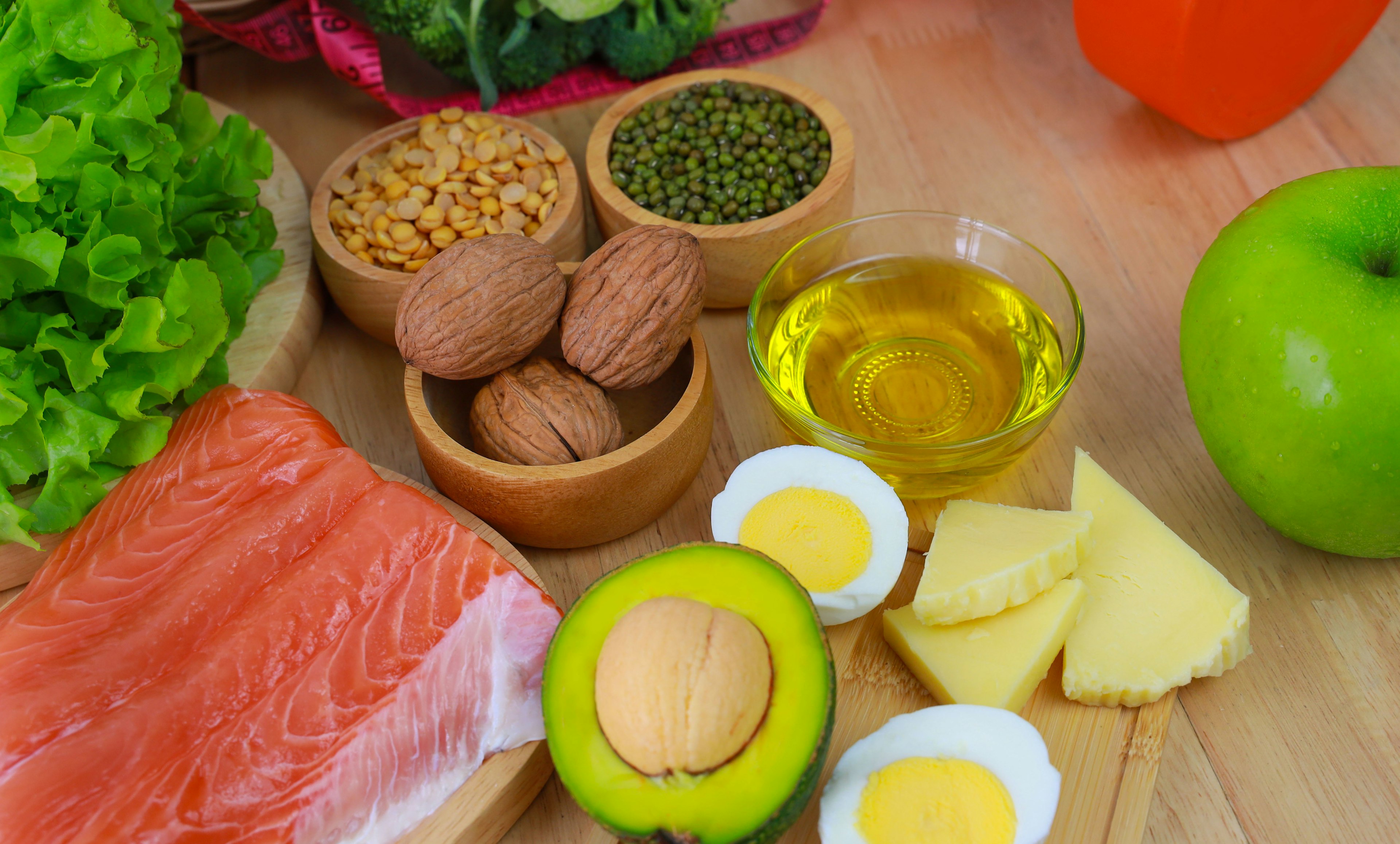 Healthy food including salmon, nuts, and olive oil that lowers cholesterol.