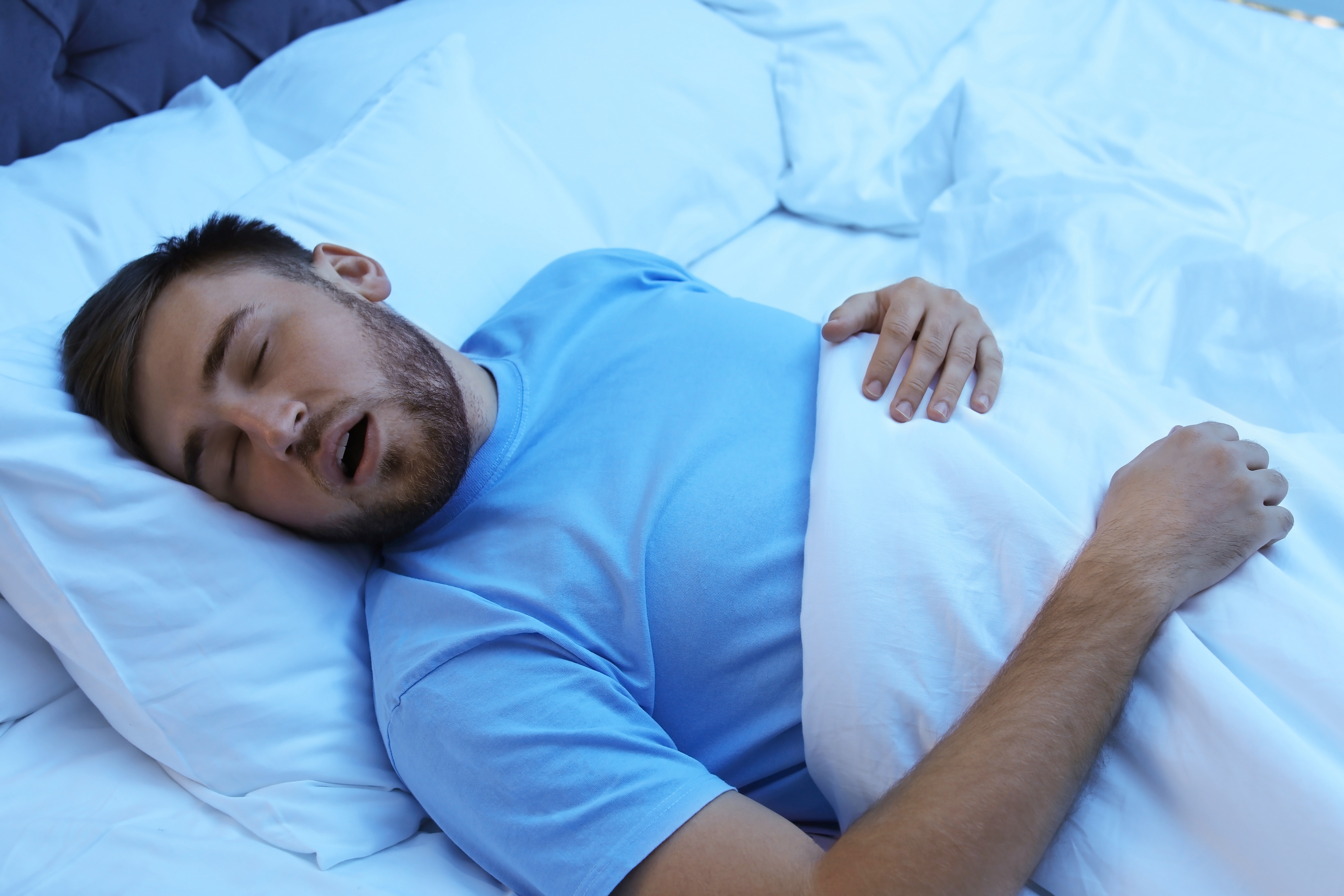 A man is snoring due to sleep apnea.