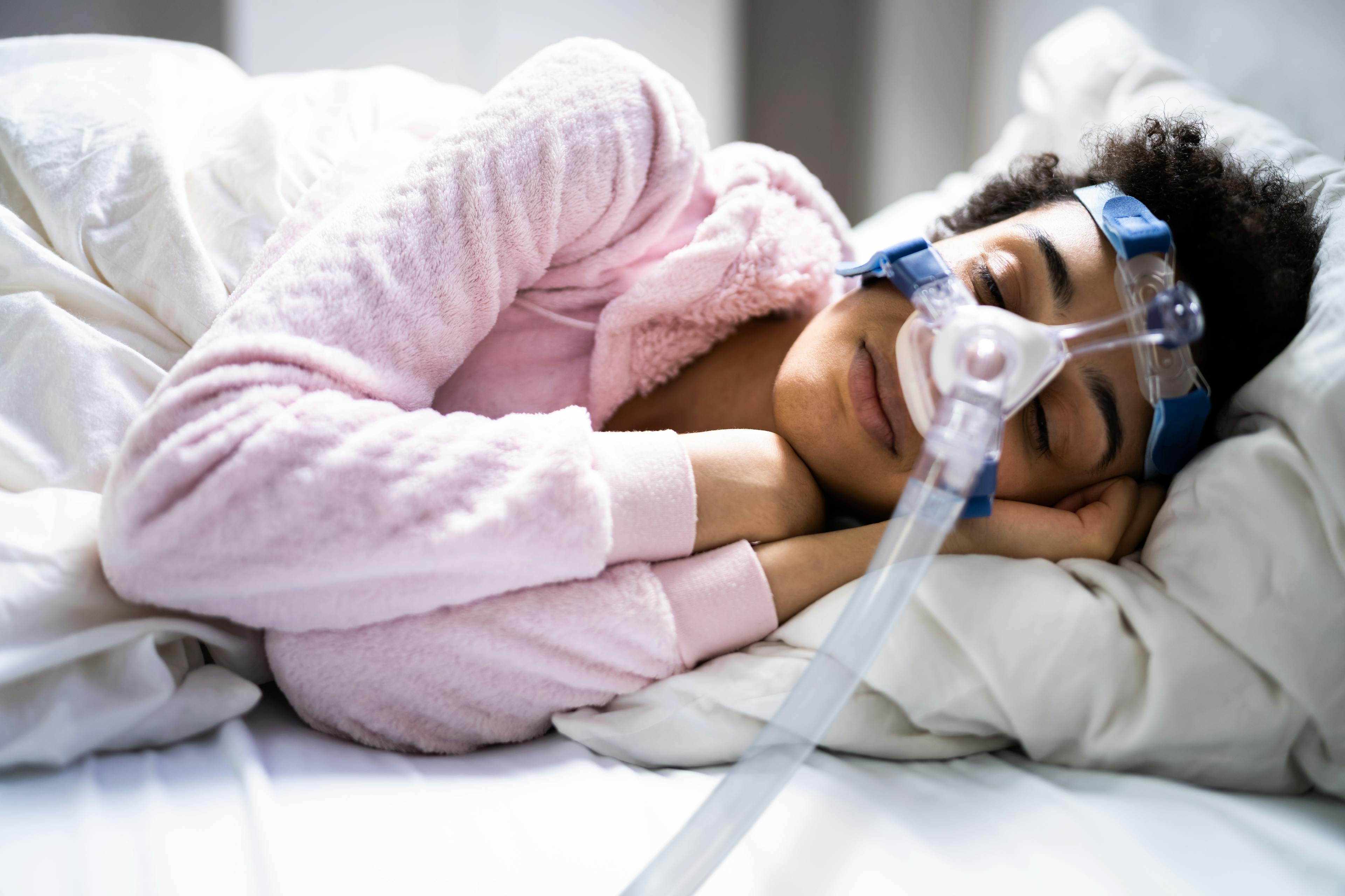 A woman is using a CPAP machine to help her sleep apnea.