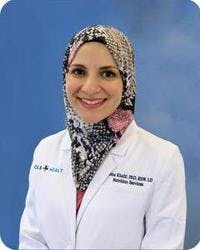 Mona Khalil, PhD, pictured in her white coat for a headshot.