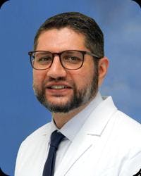 Salman Mian, MD, a pain management doctor, in his white coat for a headshot.