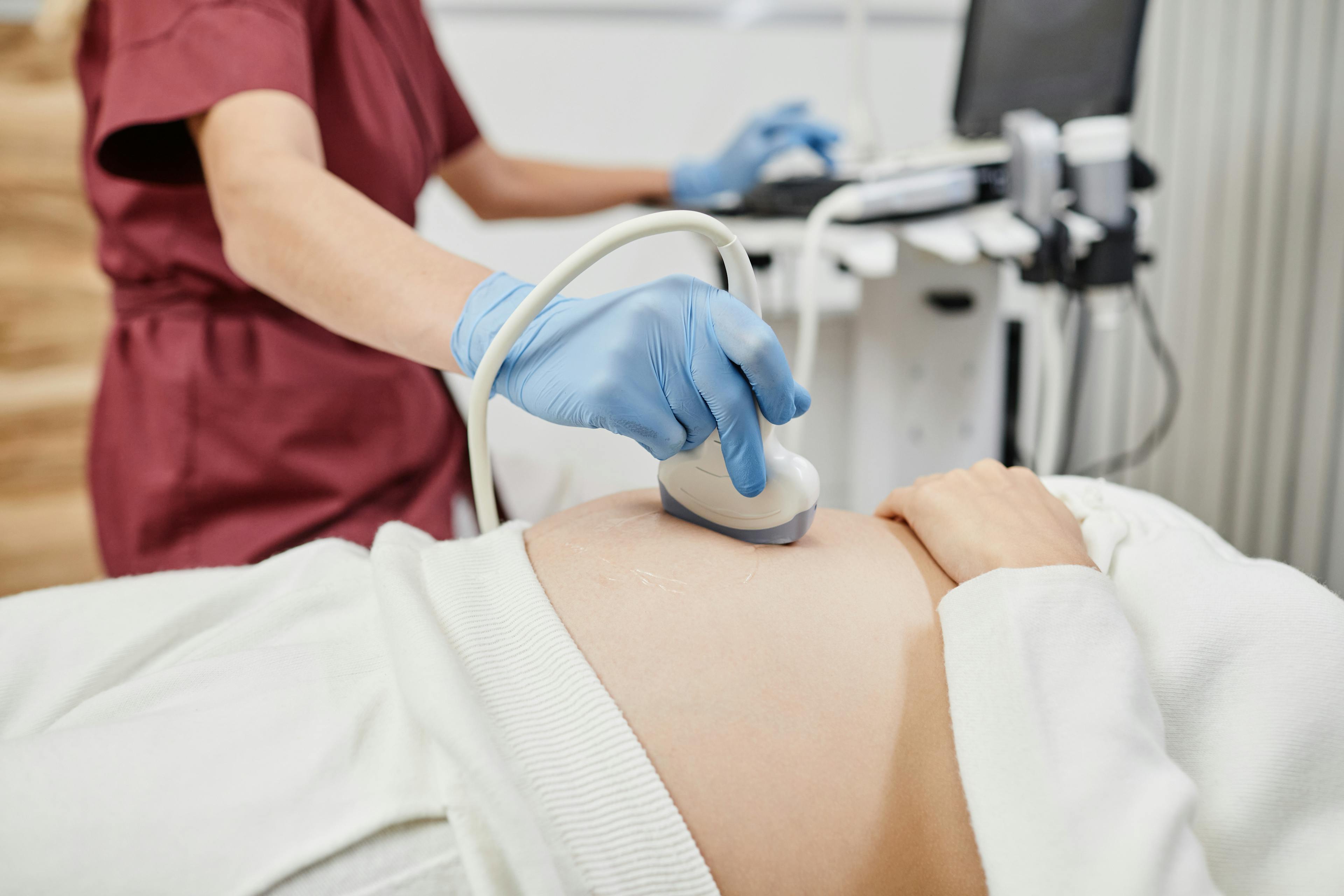 OBGYN doctor performing an ultra-sound exam on pregnant patient.