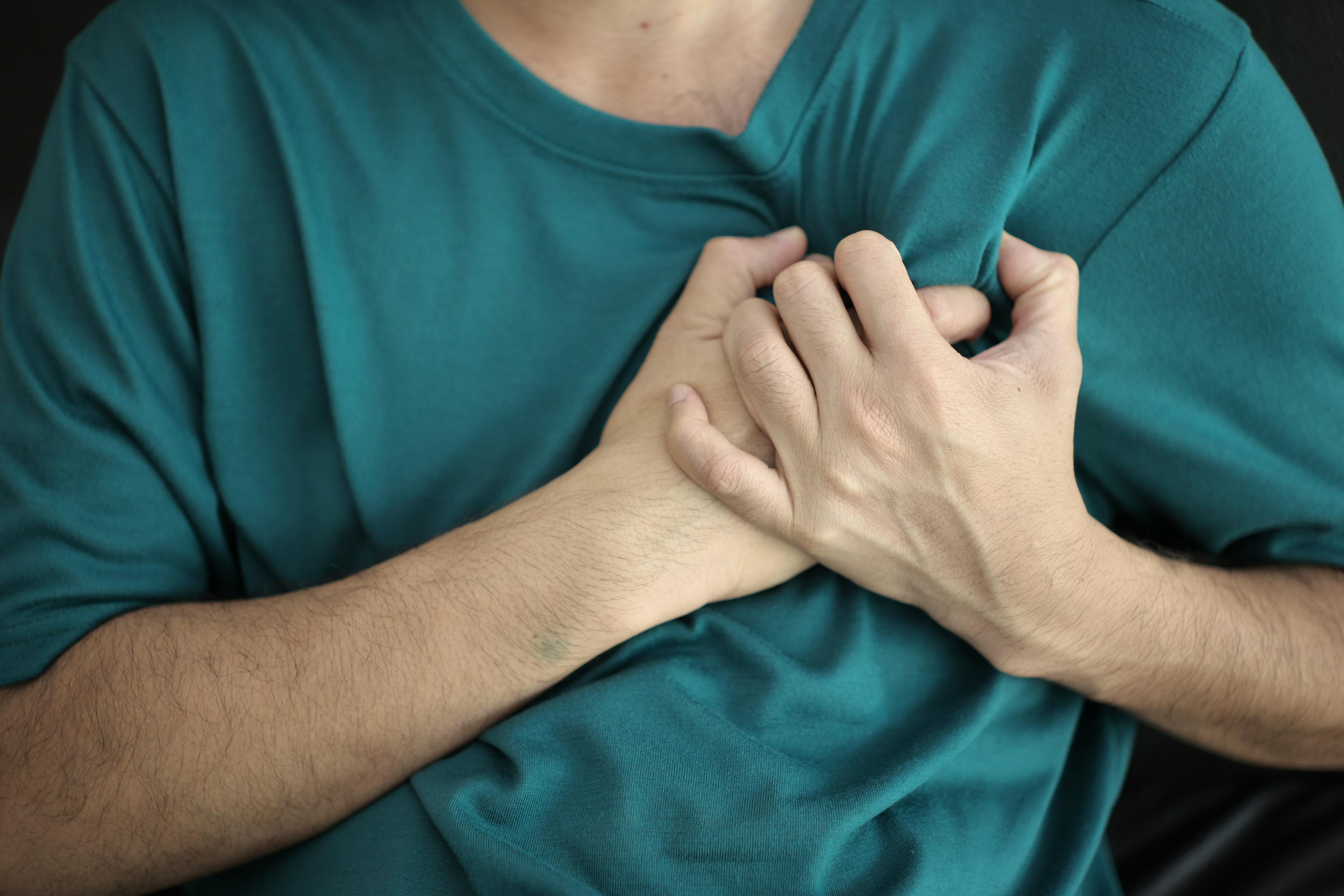 Man clutching his chest from heart pain.