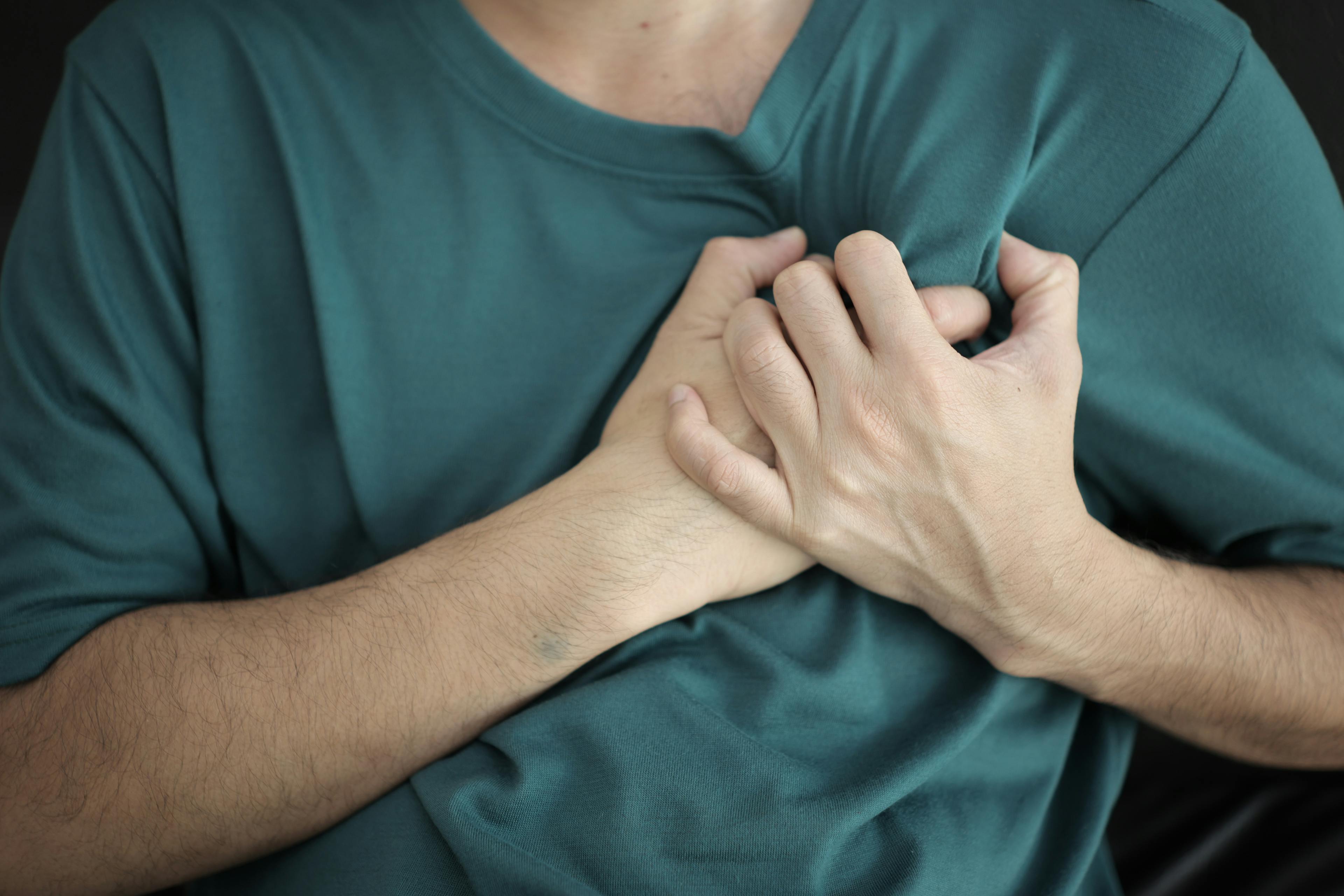 Man clutching his chest from heart pain.