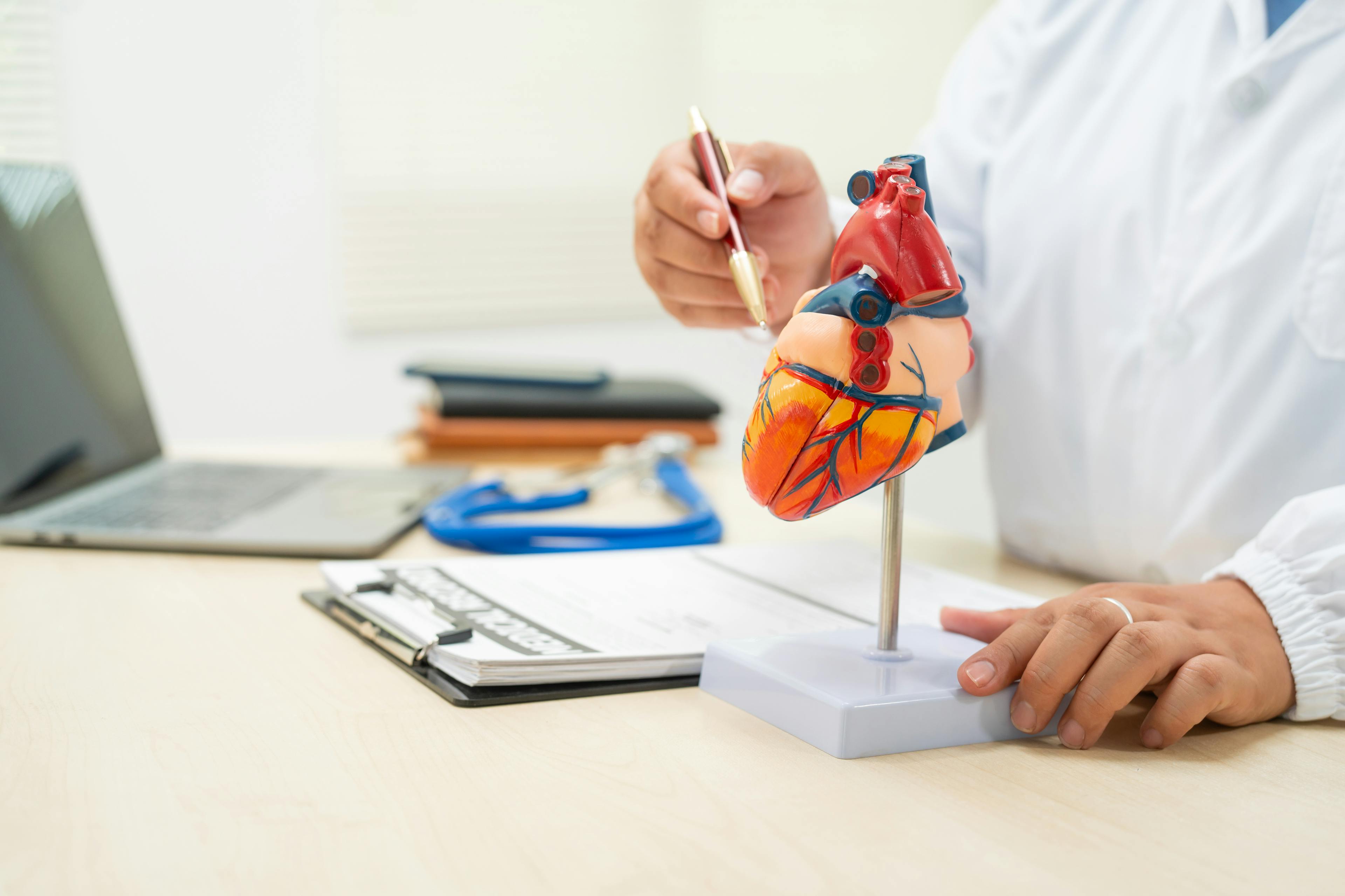 A female doctor works at a desk in the hospital,discussing heart diseases.