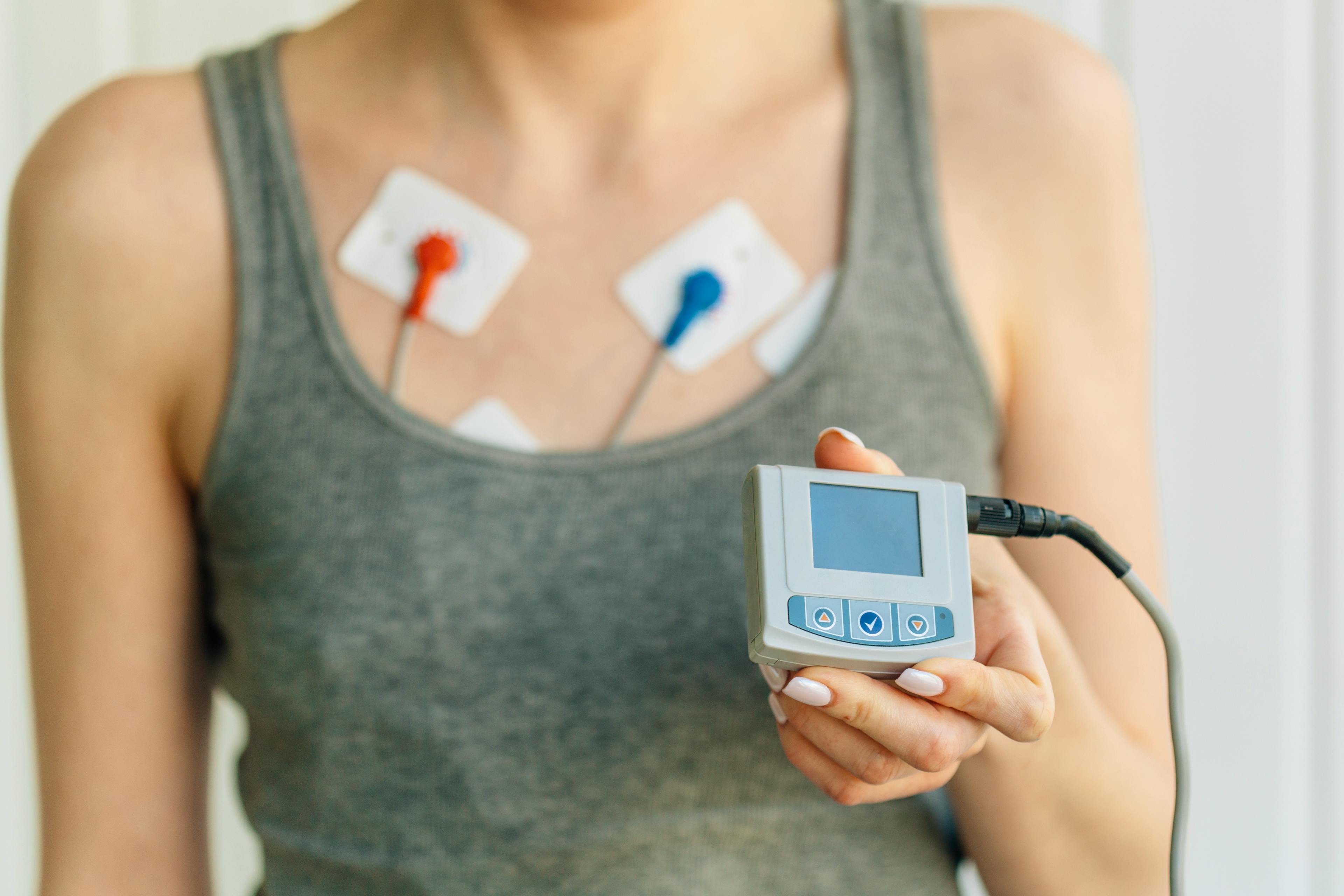 Woman wearing holter monitor device for daily monitoring of an electrocardiogram.