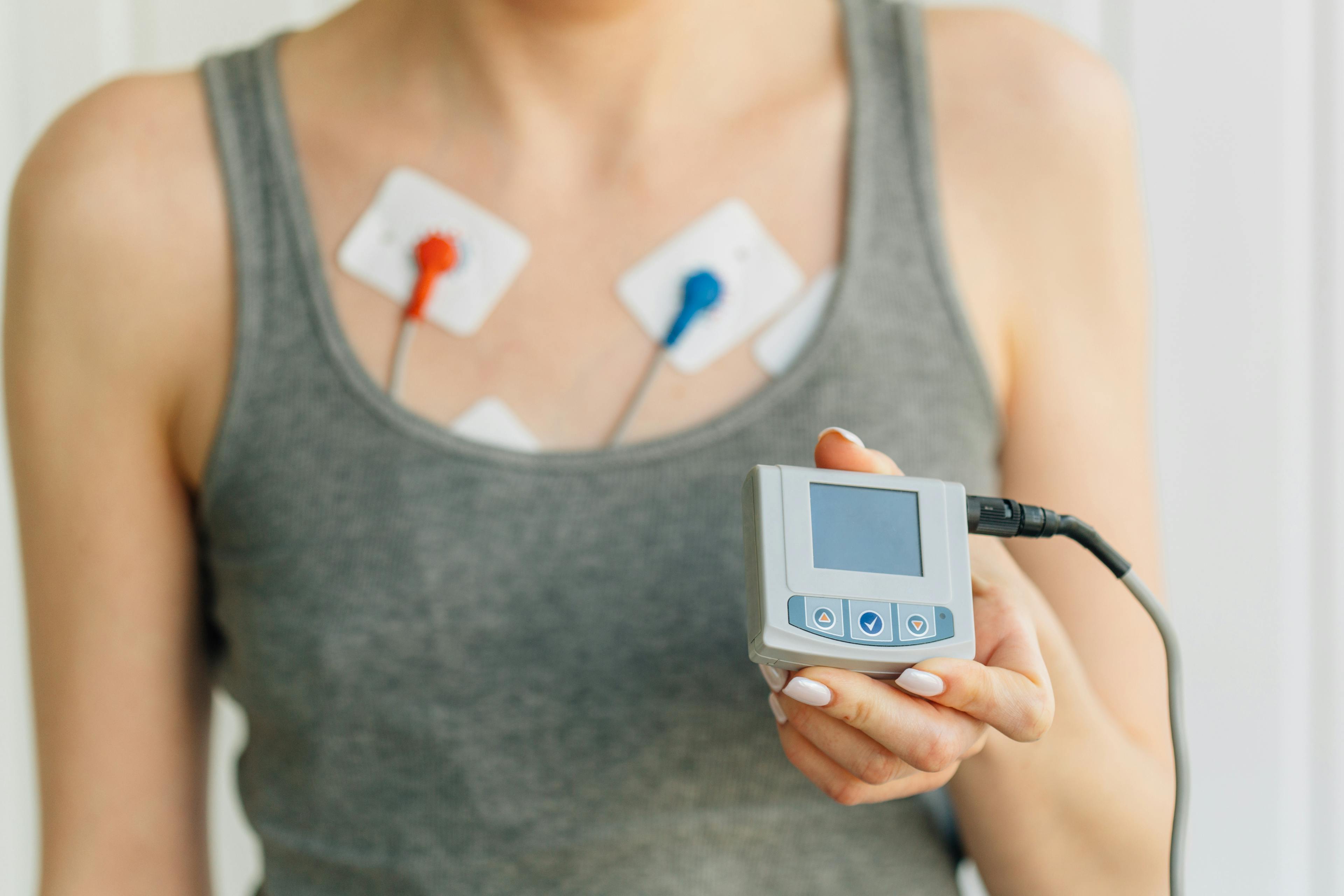 Woman wearing holter monitor device for daily monitoring of an electrocardiogram. 
