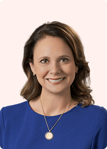 CLS Health's CEO, Megan Owen, posing for her headshot in a dark blue blouse.