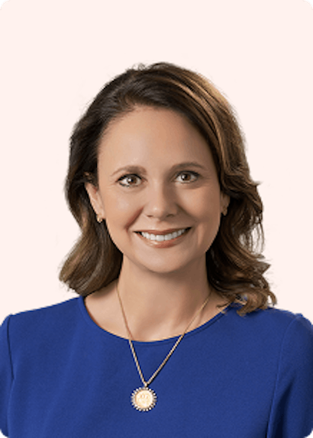 CLS Health's CEO, Megan Owen, posing for her headshot in a dark blue blouse. 
