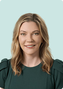 CLS Health's COO, Misty Berger, posing for her headshot in a dark green blouse.