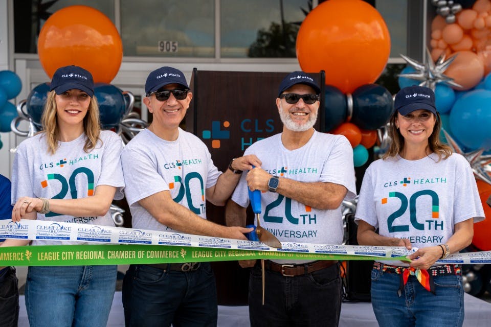 Dr. Baba, President, Dr. Dweik, Vice President, Megan Owen, CEO, and Misty Berger, COO, posing for a ribbon cutting to celebrate CLS Health's 20th anniversary.