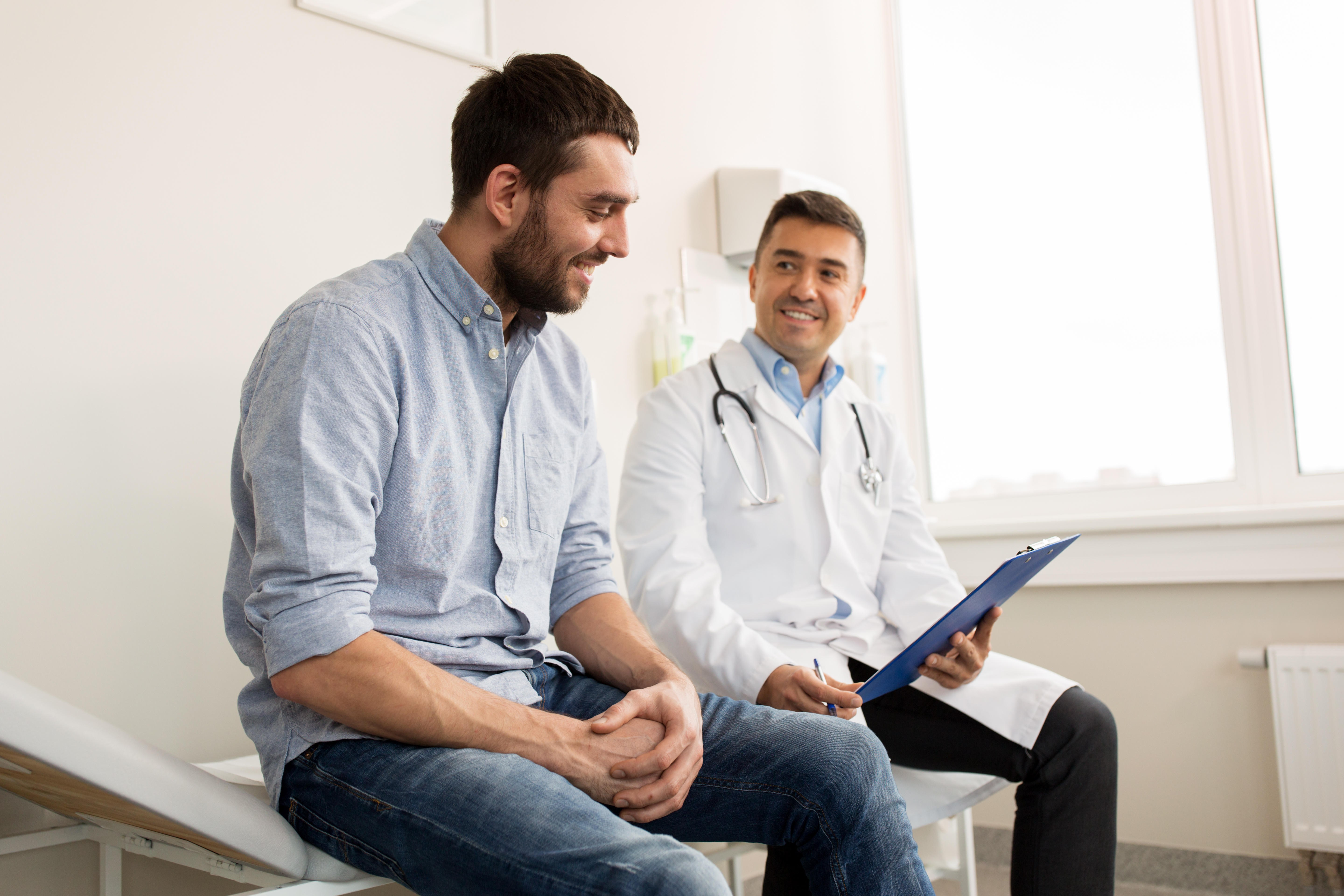 A happy male patient is having a good discussion with his doctor. 