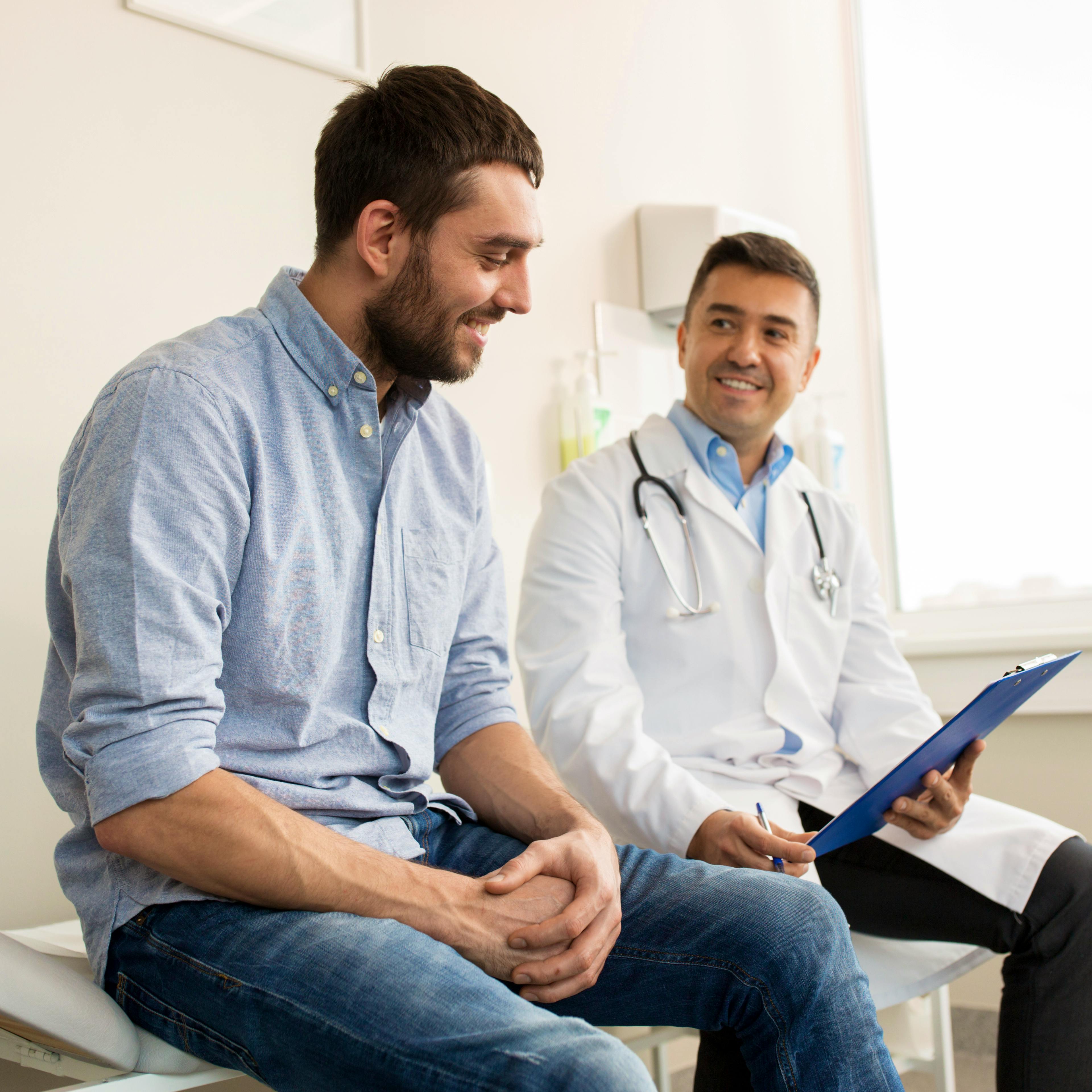 A happy male patient is having a good discussion with his doctor.