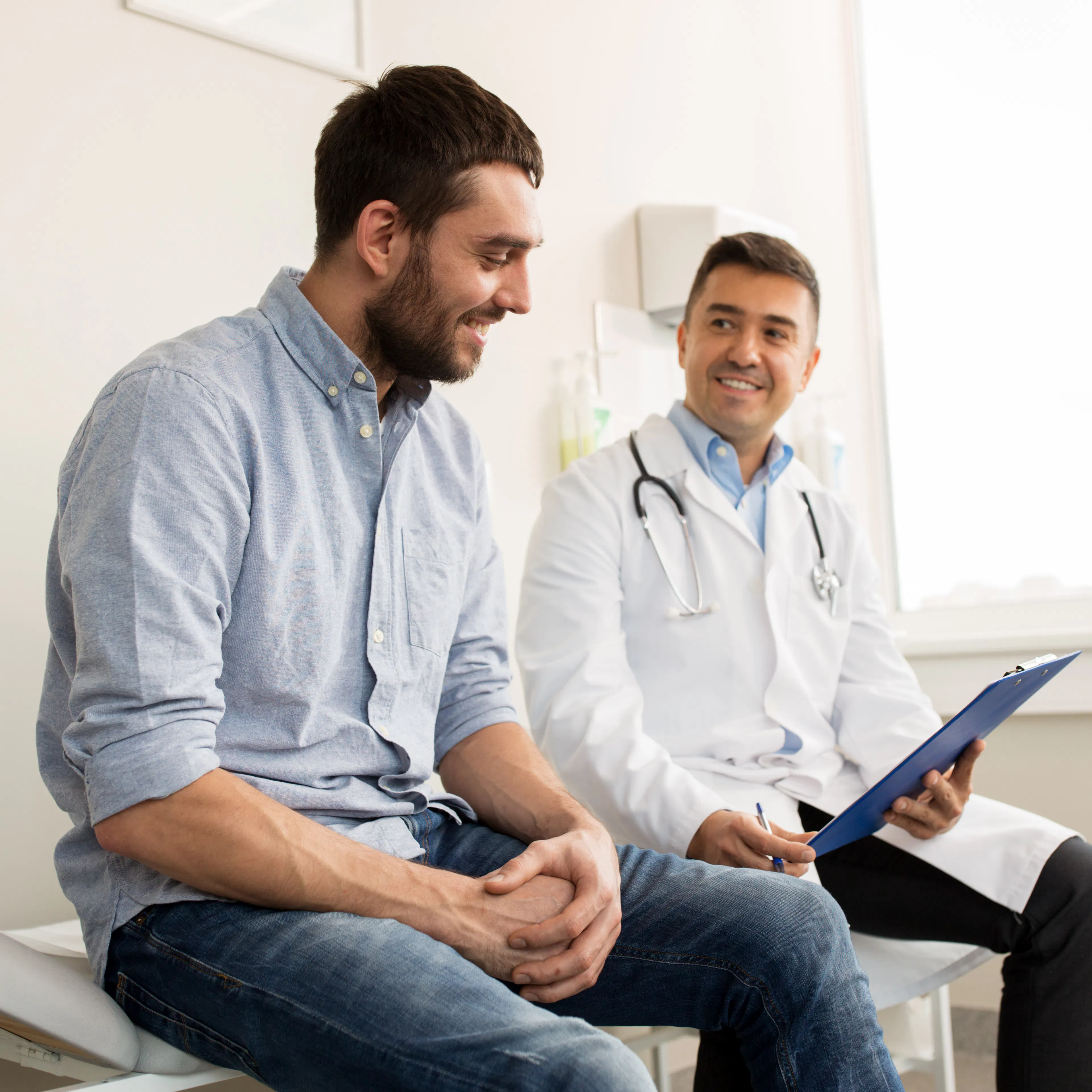 A happy male patient is having a good discussion with his doctor. 