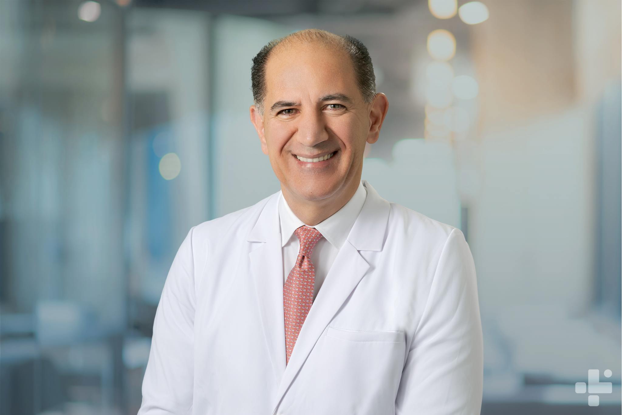 Vice President of CLS Health, Mahmood Dweik, MD, posing for his headshot in his white coat.