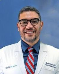 Sugar Land pediatrician, Khaled Mohammed, MD, posing for his headshot in his white coat.