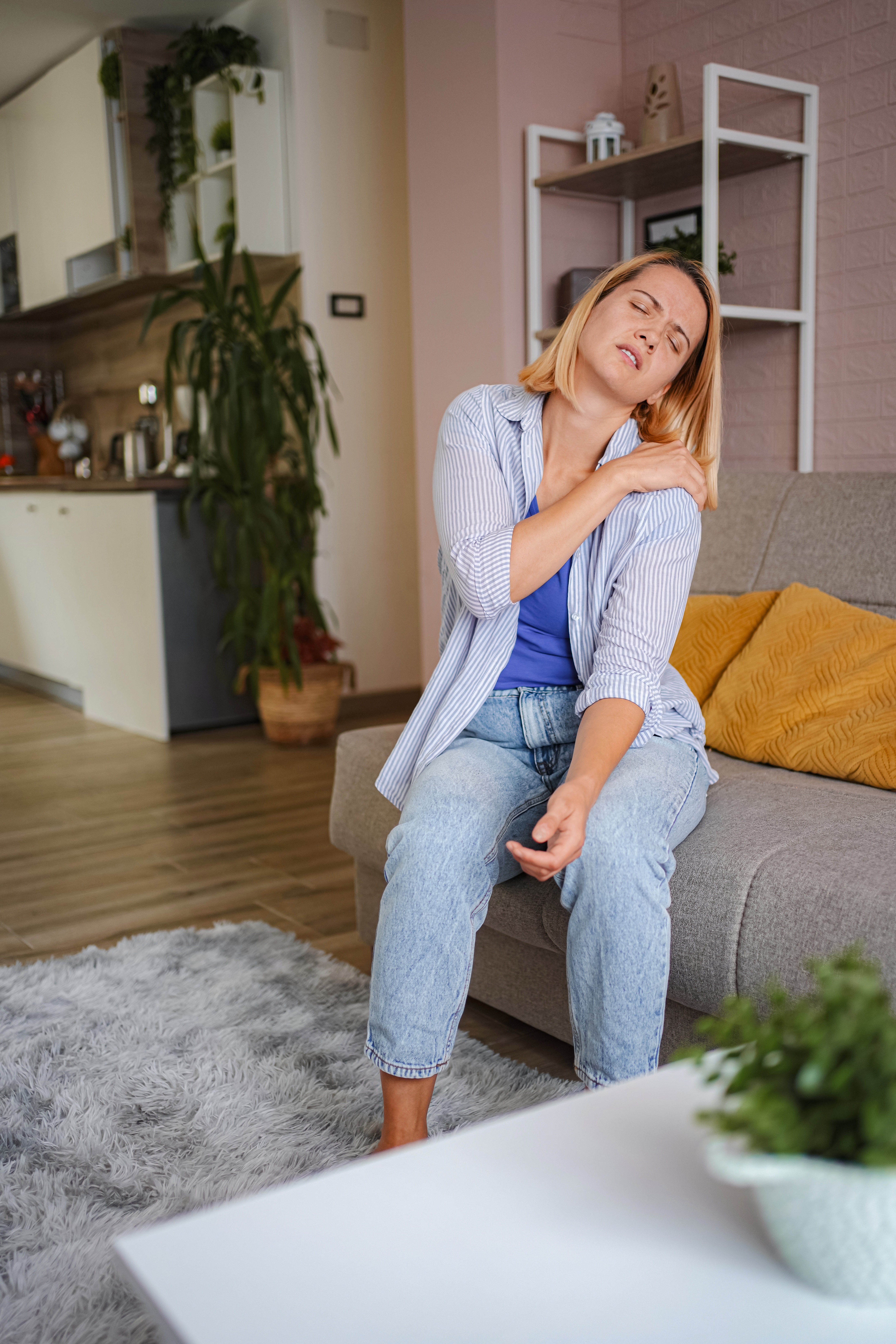 A woman is holding her rotator cuff in pain. 