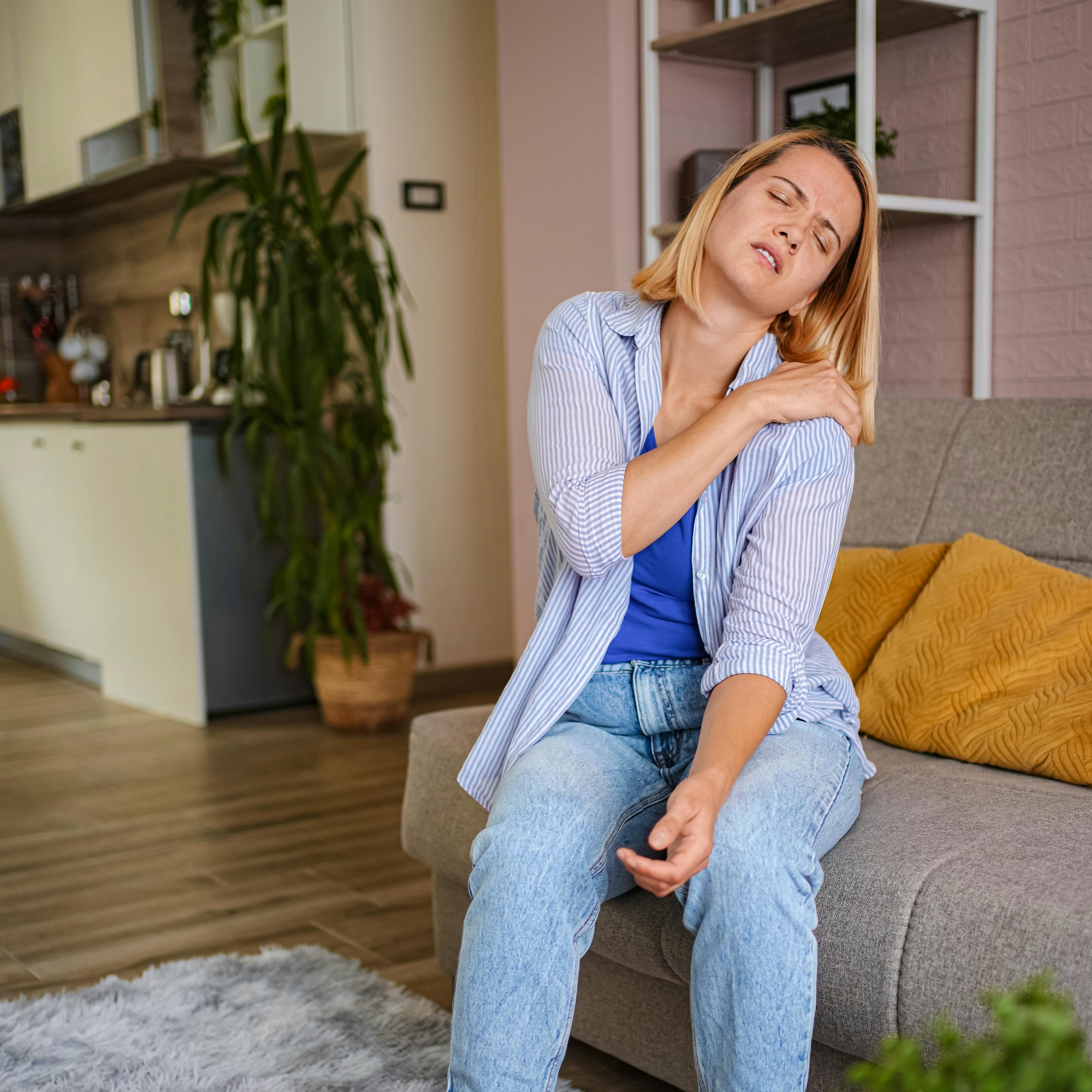 A woman is holding her rotator cuff in pain.