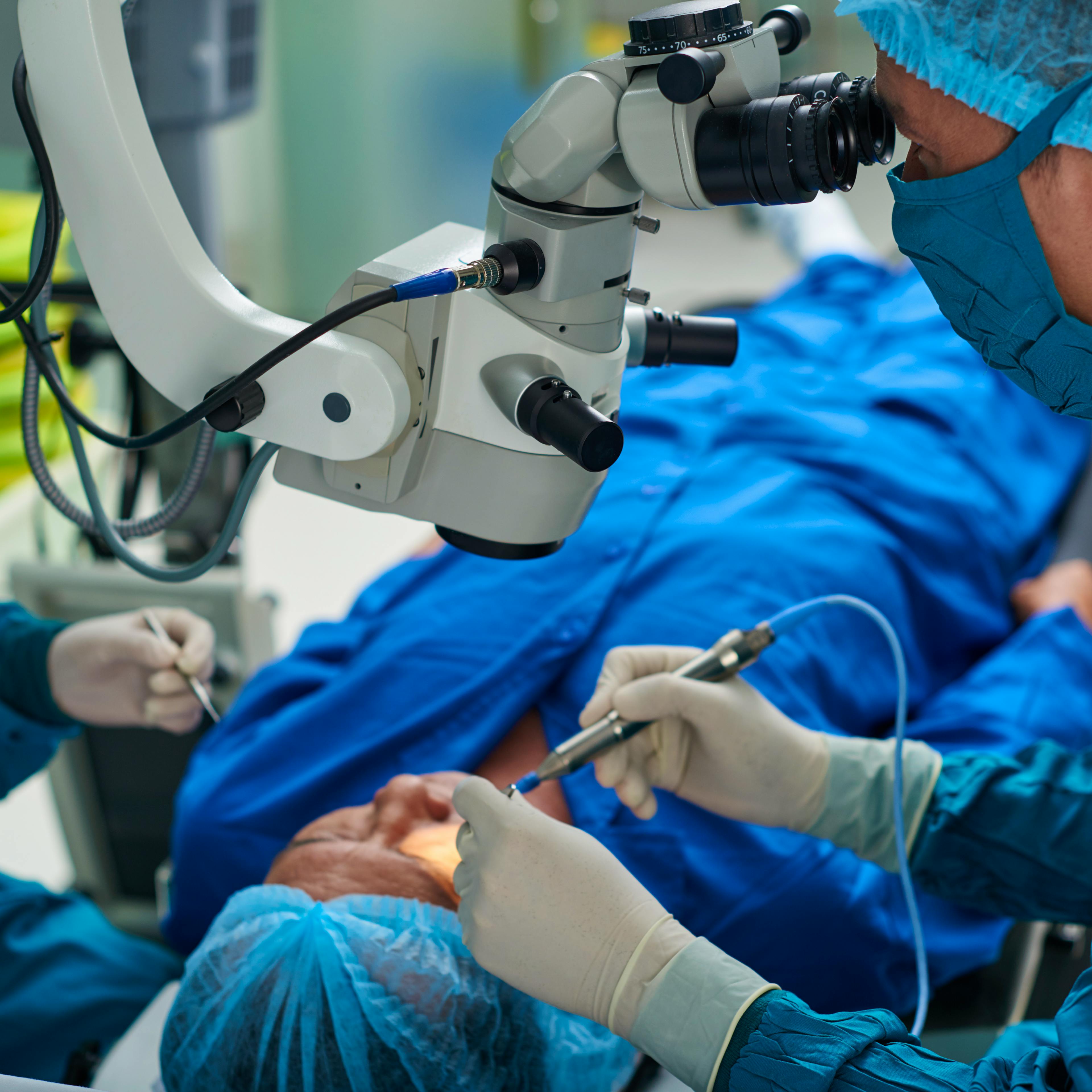 Ophthalmologists are performing eye surgery on a patient.